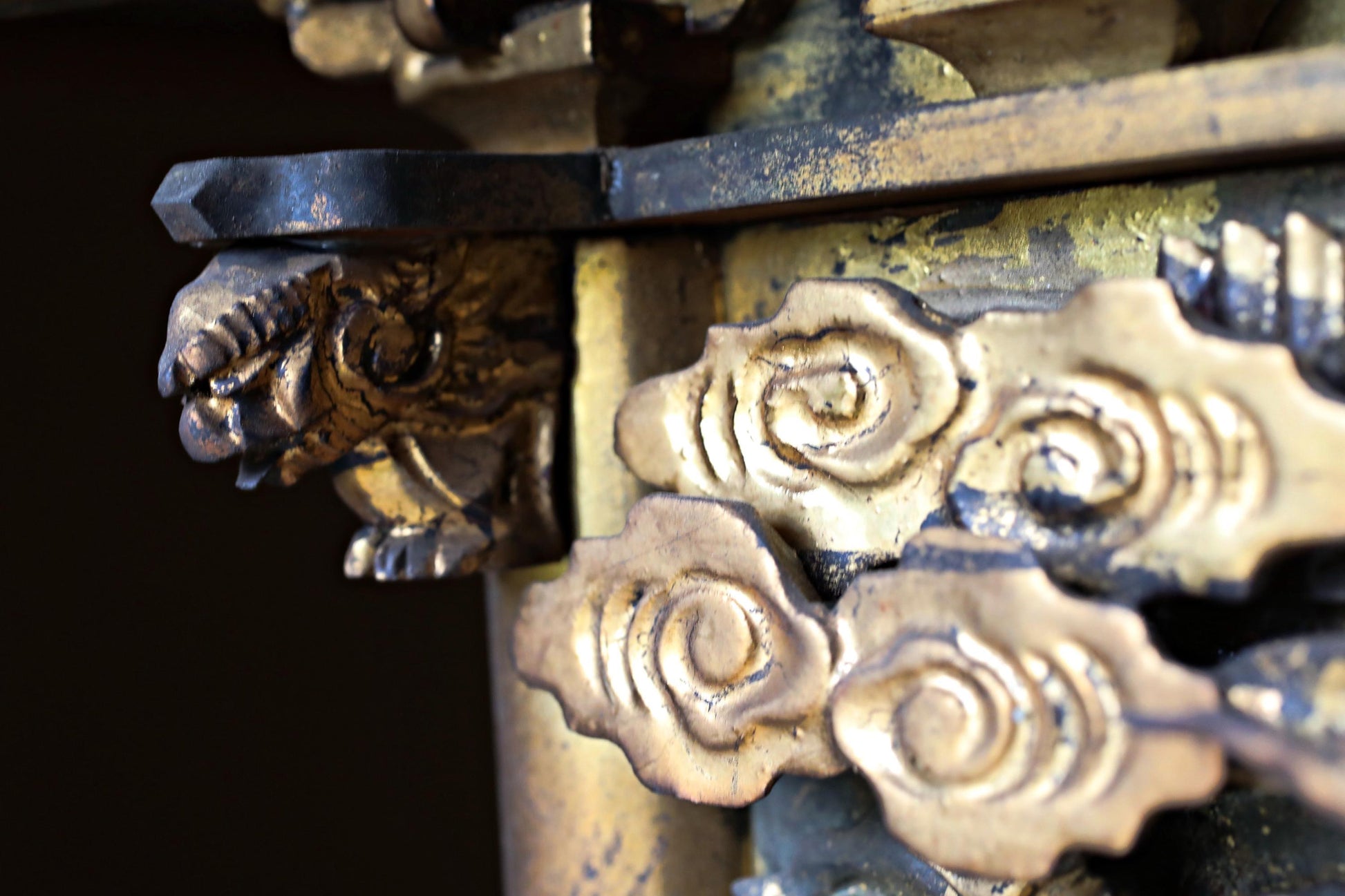 intricate, ornate, and gilded details, including a dragon head and clouds, which are part of a decorative piece.