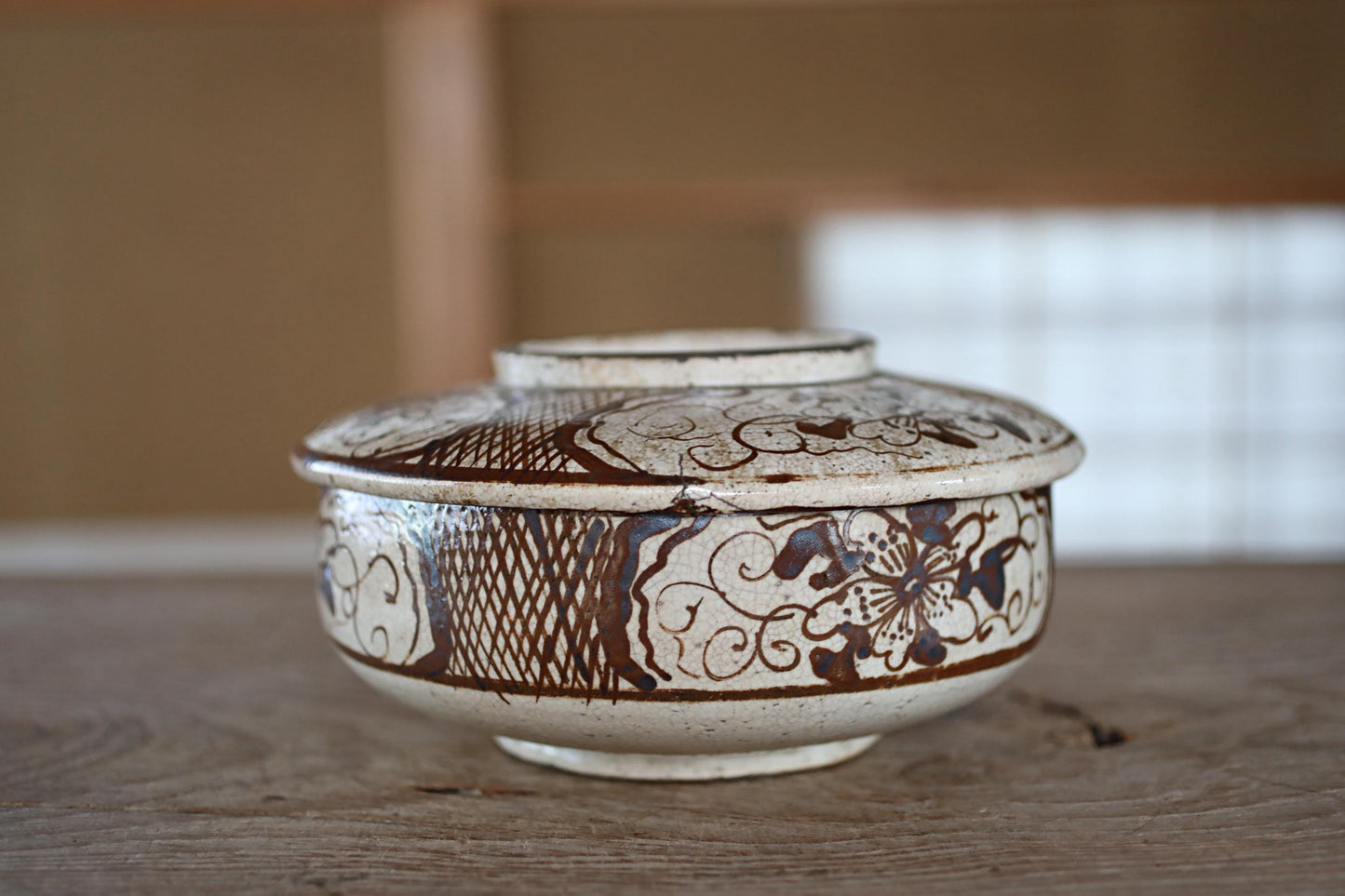 A decorative ceramic bowl with intricate patterns and designs, sitting on a wooden surface.