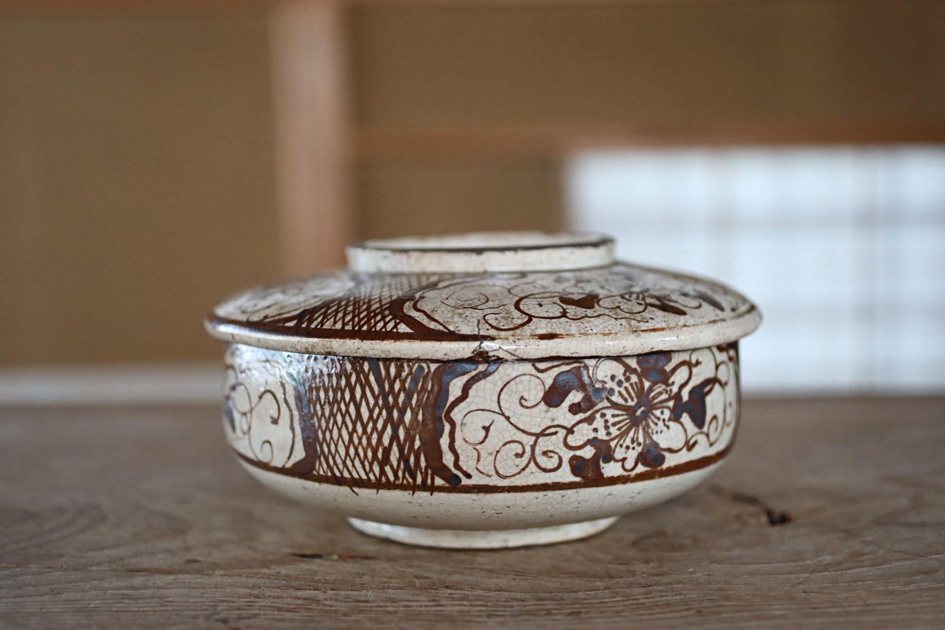 A decorative ceramic bowl with intricate patterns and designs, sitting on a wooden surface.