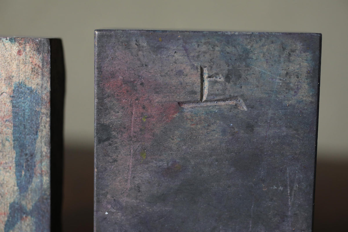 a close-up view of a metal surface with a carved symbol or logo on it.