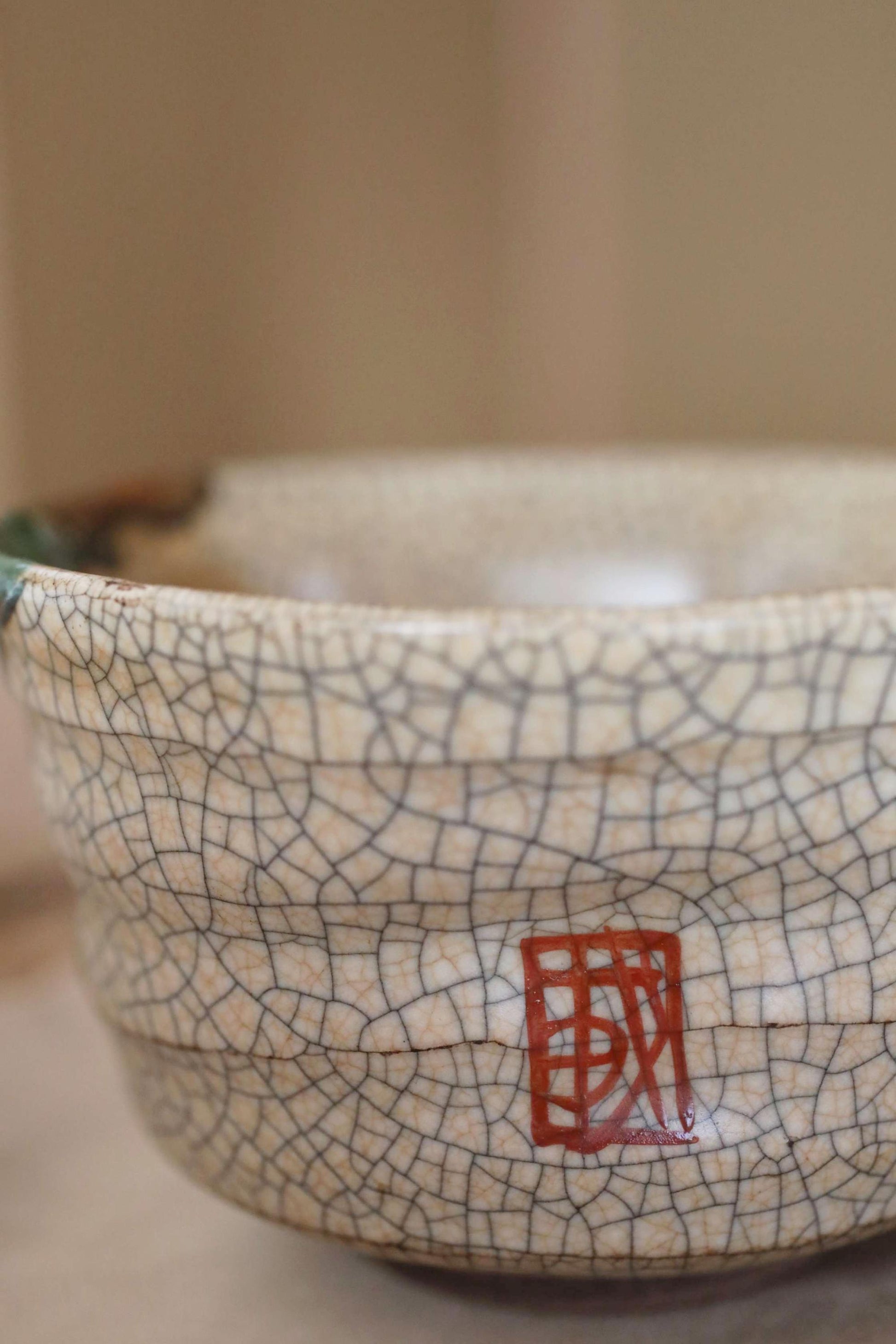 A close-up image of a ceramic bowl with a red symbol on it.
