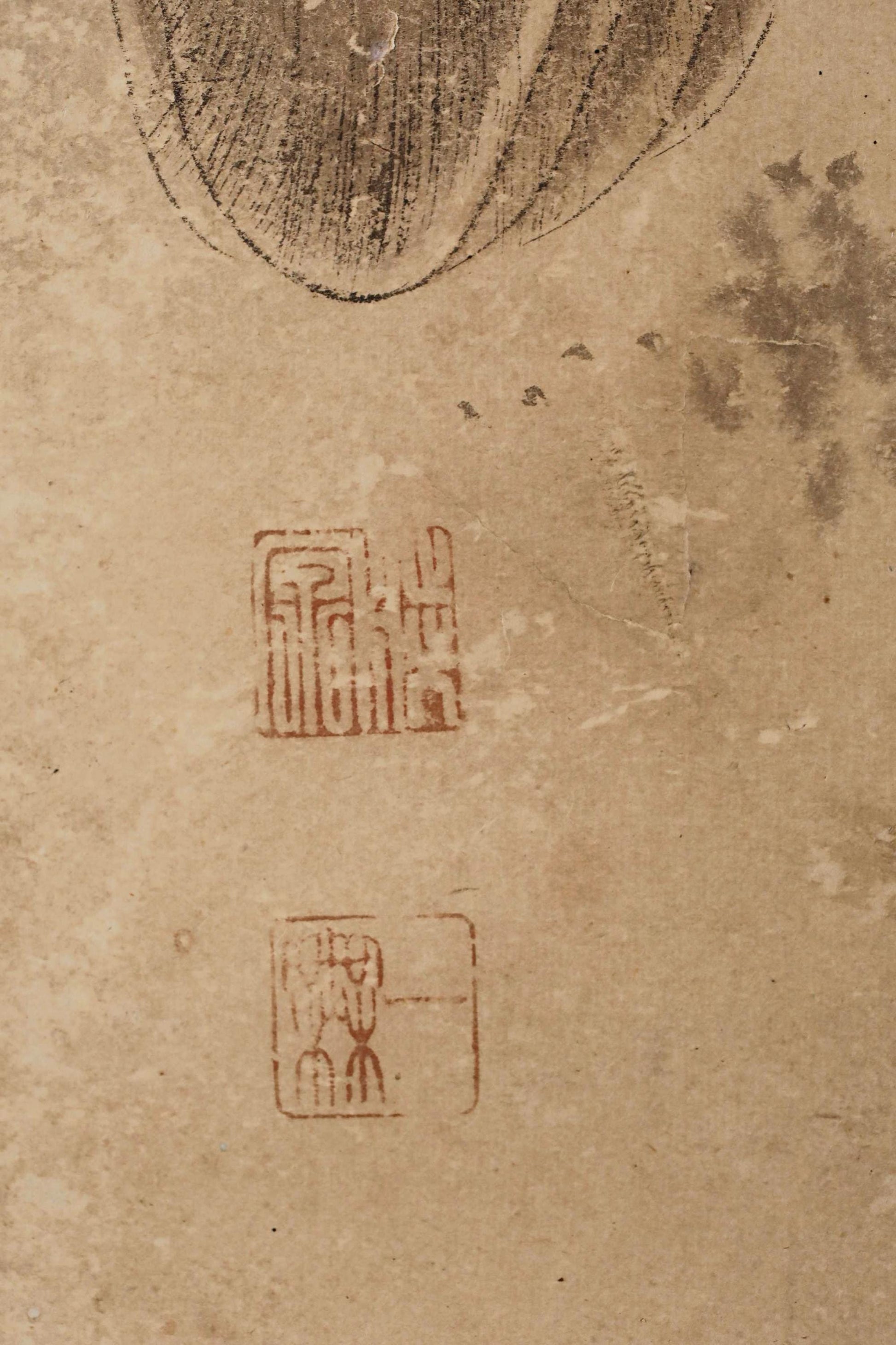 a close-up view of a textured surface with various markings and symbols, including a small red square with a symbol and a larger red square with a similar symbol.