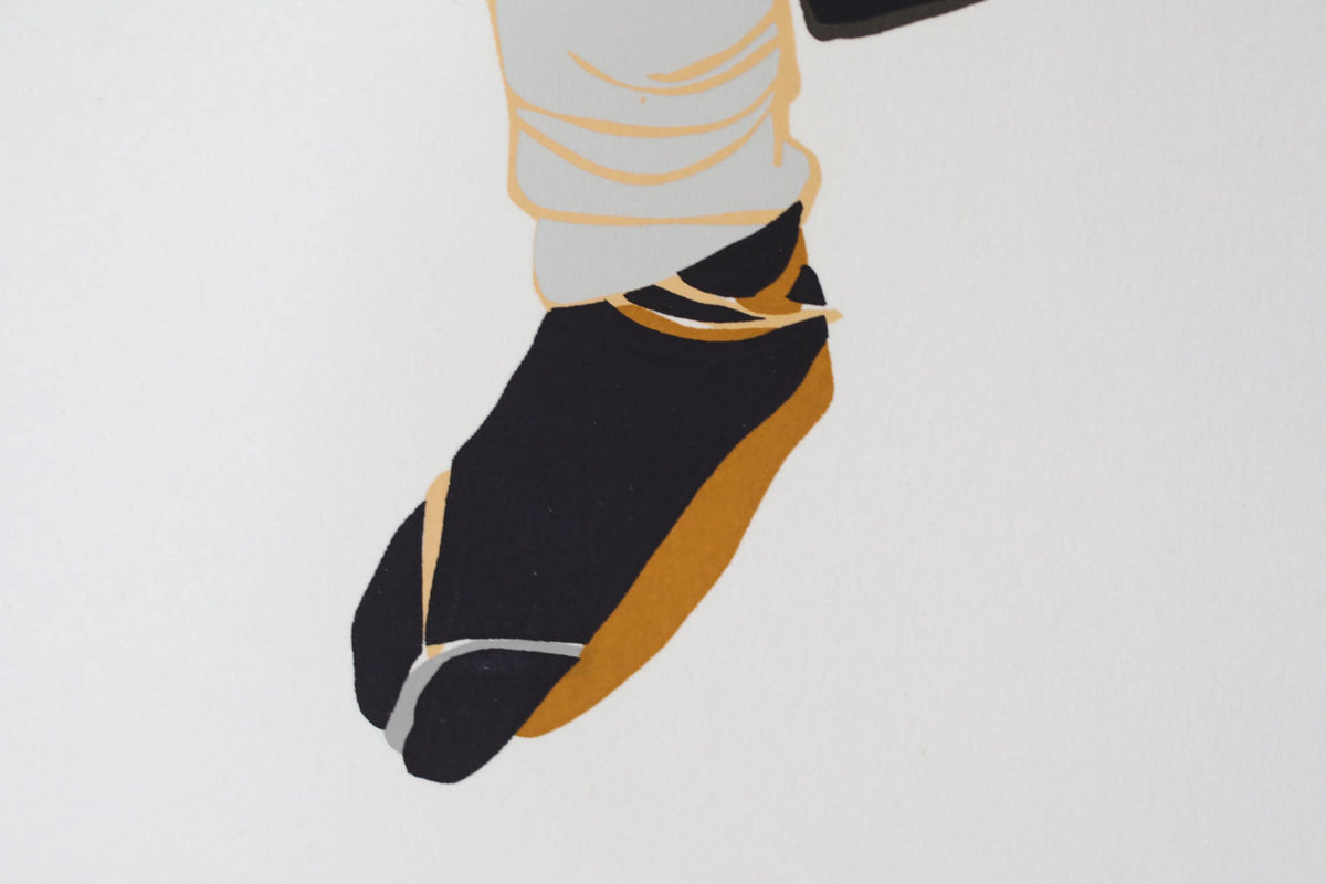 a close-up view of a person's foot wearing black and gold shoes.
