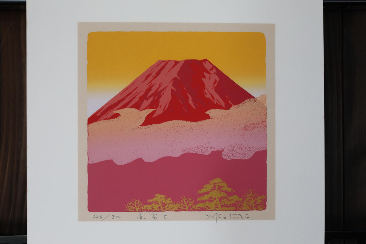 a vibrant red mountain against a warm yellow and pink sky, with a few small trees in the foreground.