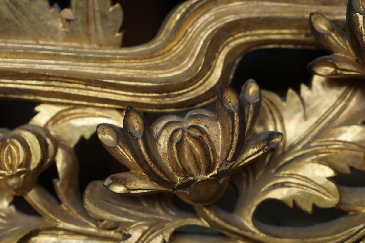 a close-up view of a detailed, ornate golden sculpture with intricate floral and leaf-like designs.