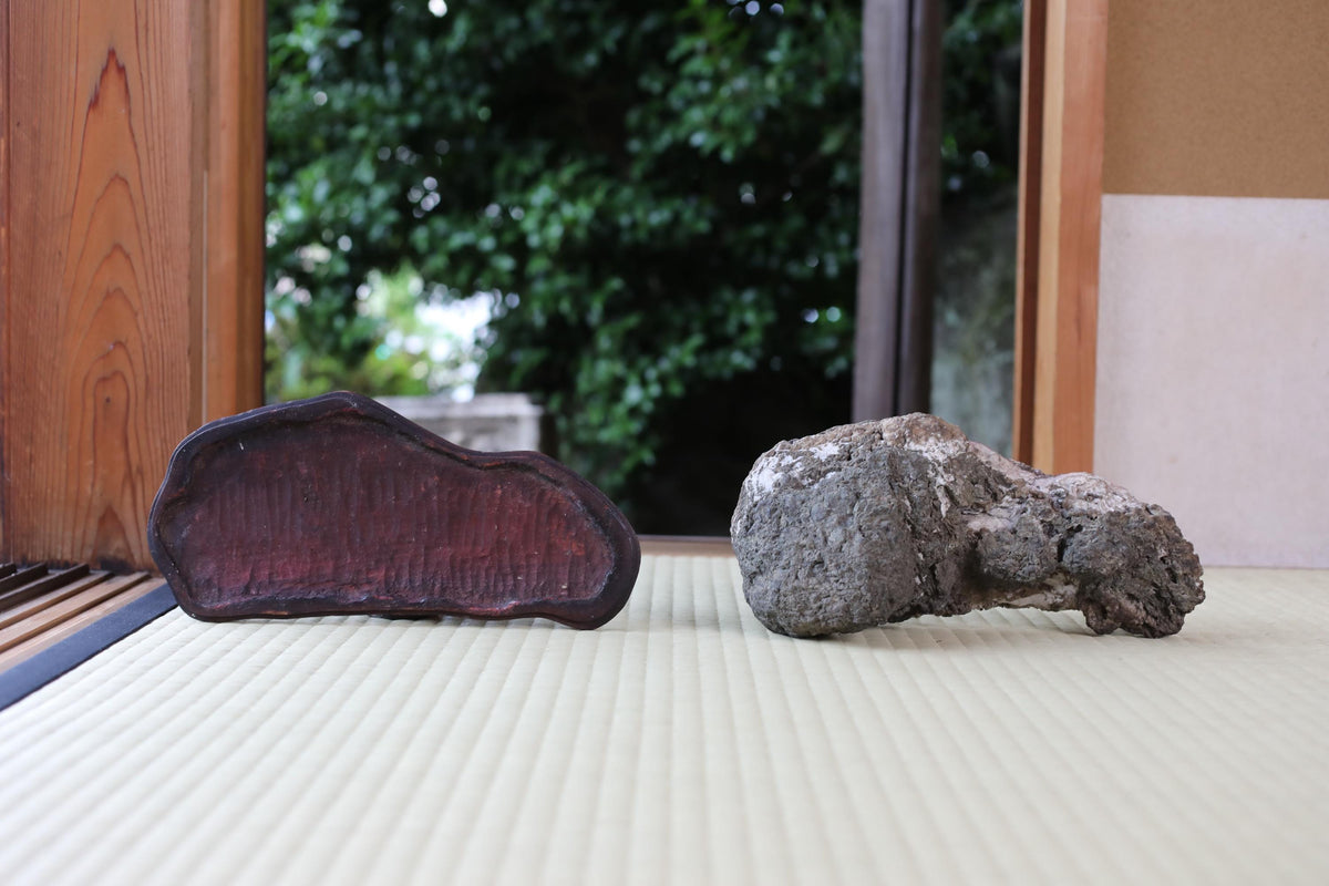two rocks placed on a mat, with a wooden frame visible in the background.