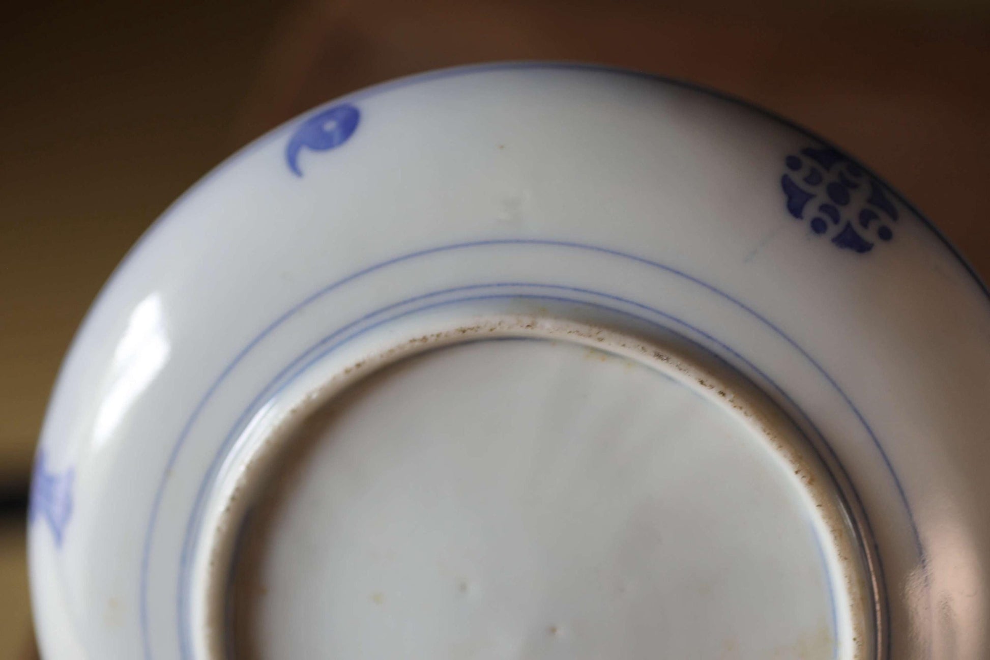 A close-up view of a white ceramic plate with blue floral designs on the rim.