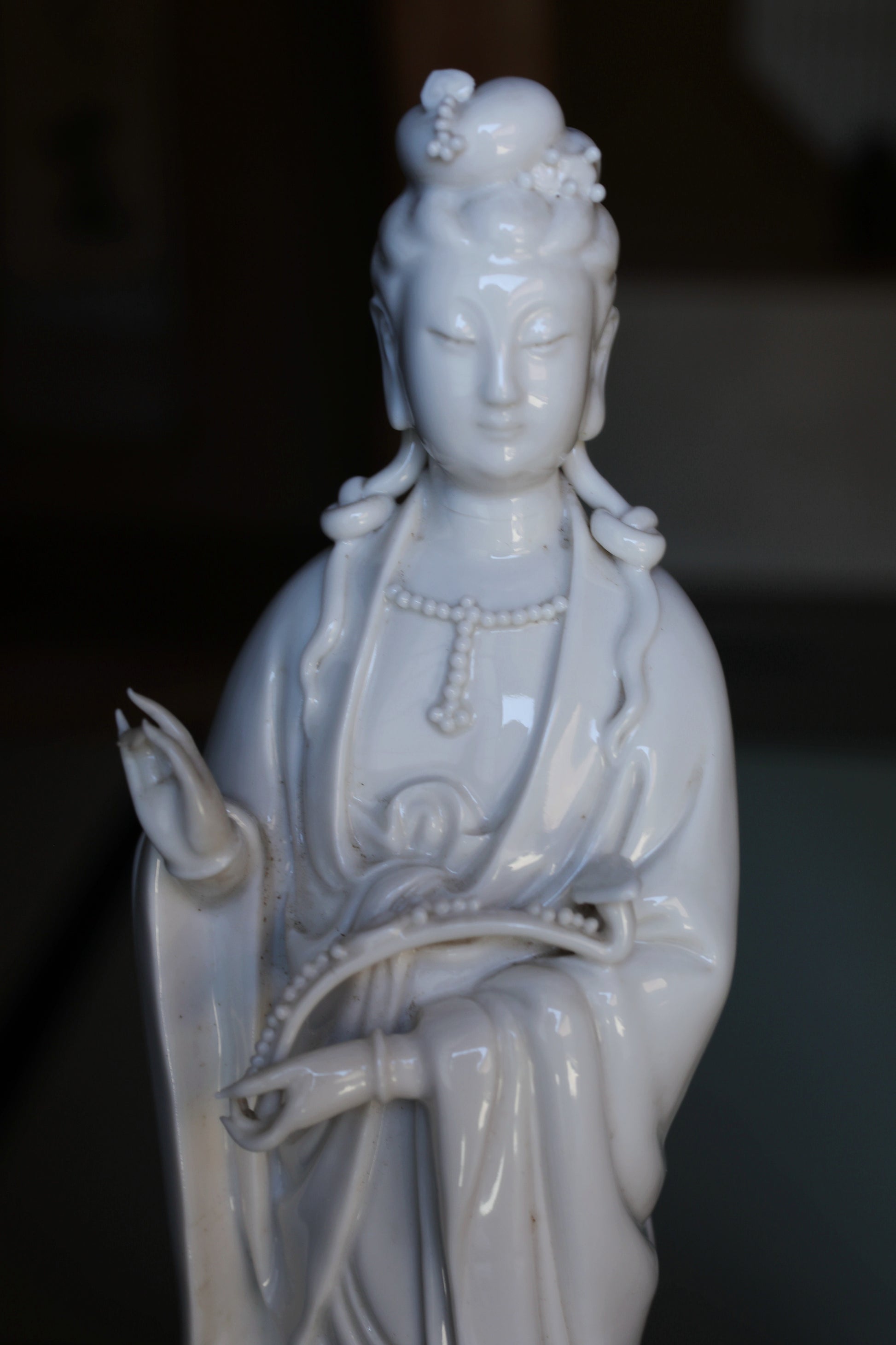 A white ceramic figurine of a deity, possibly a Buddhist or Hindu deity, with intricate details and a serene expression.