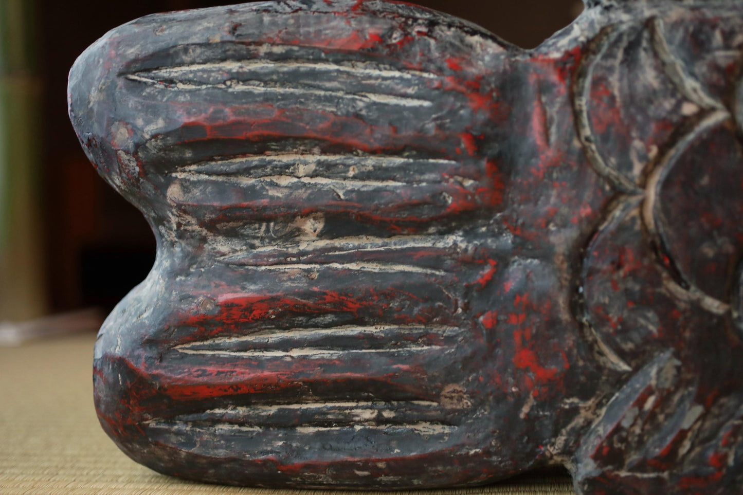 a close-up view of a weathered, textured surface with a red and black color scheme.