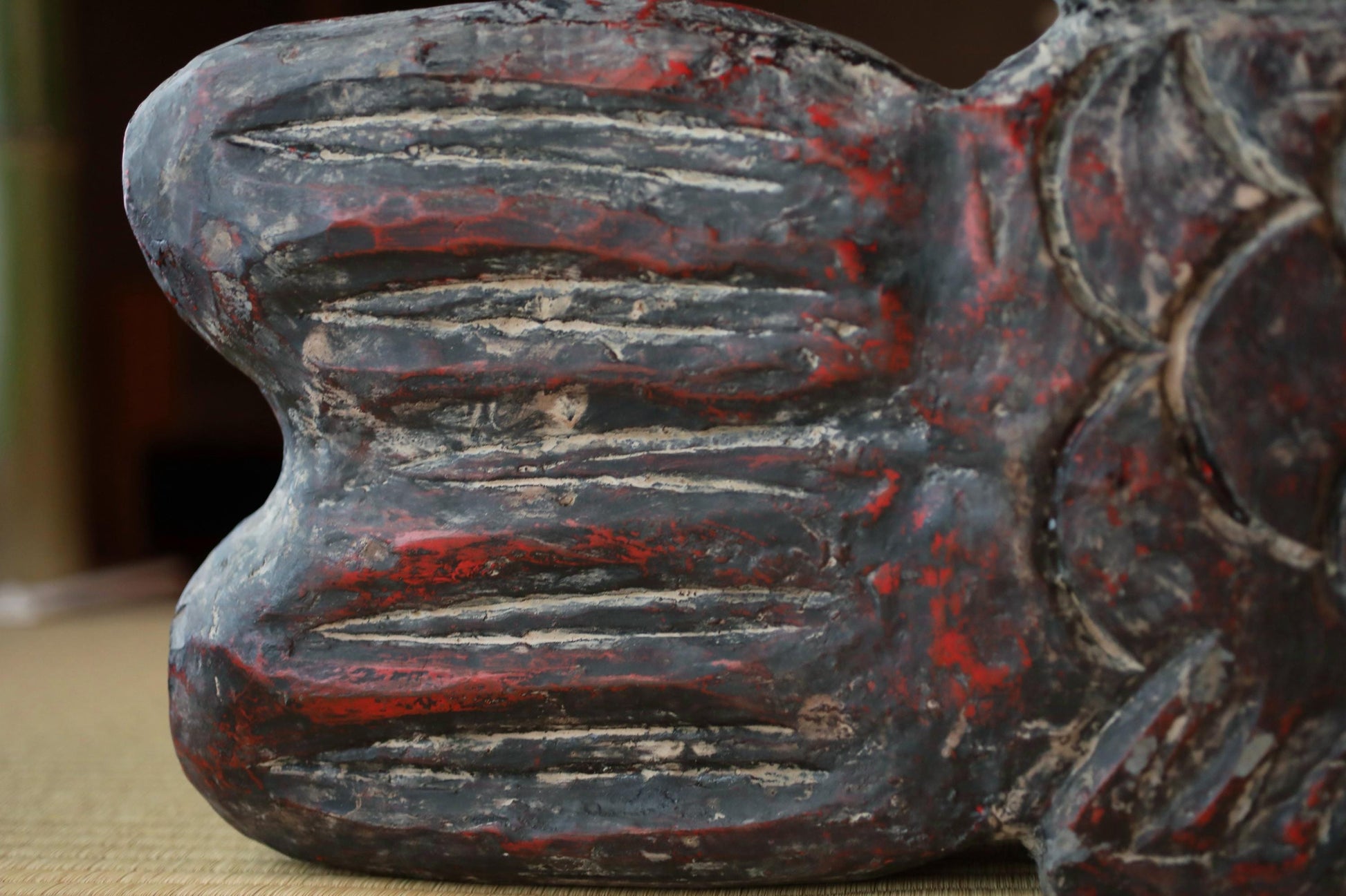 a close-up view of a weathered, textured surface with a red and black color scheme.