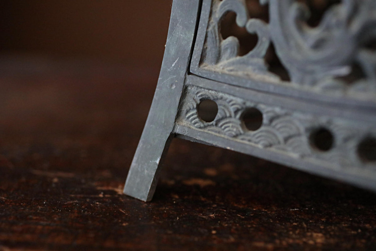 A close-up view of a decorative metal object, possibly a sculpture or a piece of furniture, with intricate designs and patterns.