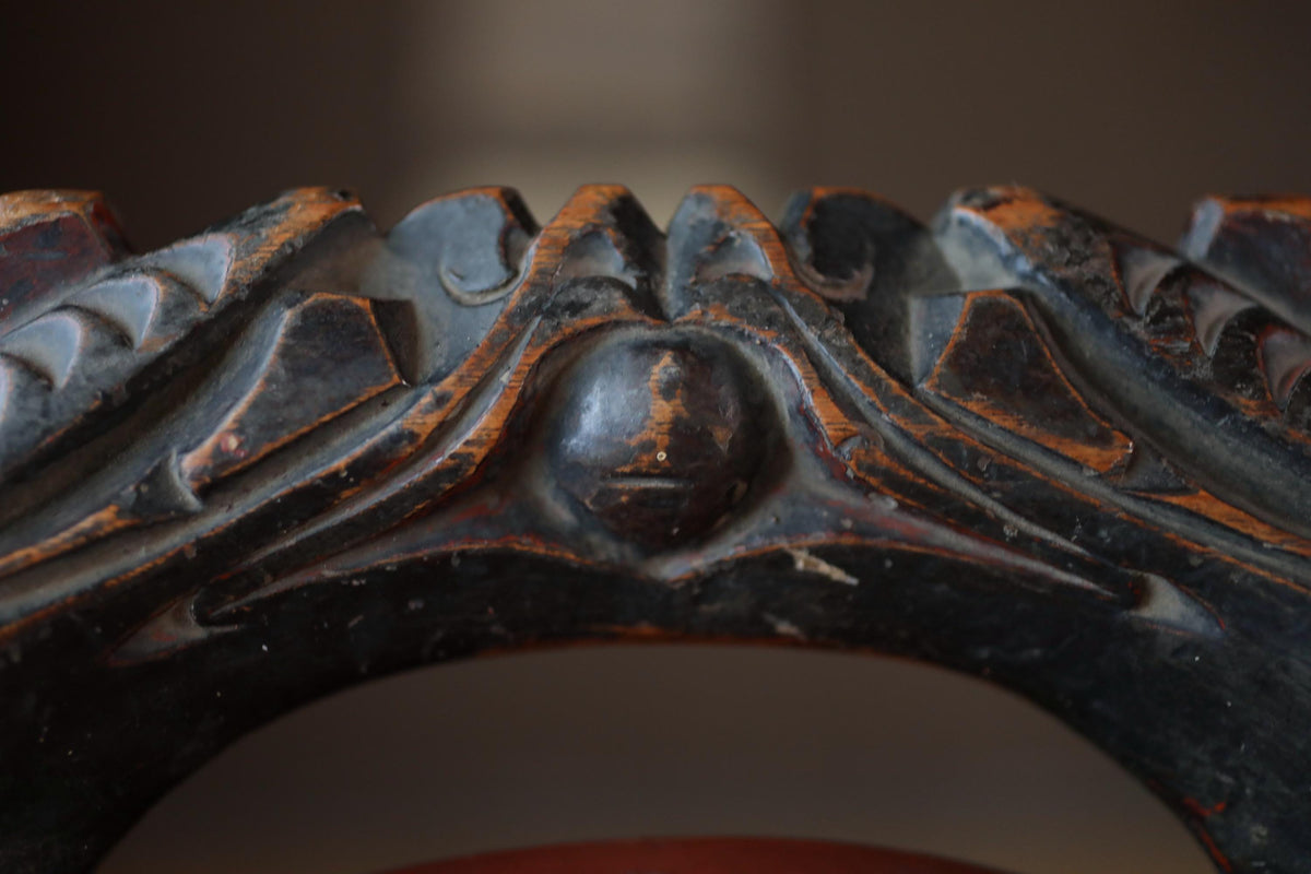 a close-up view of an ornate, carved wooden piece with intricate details and patterns.