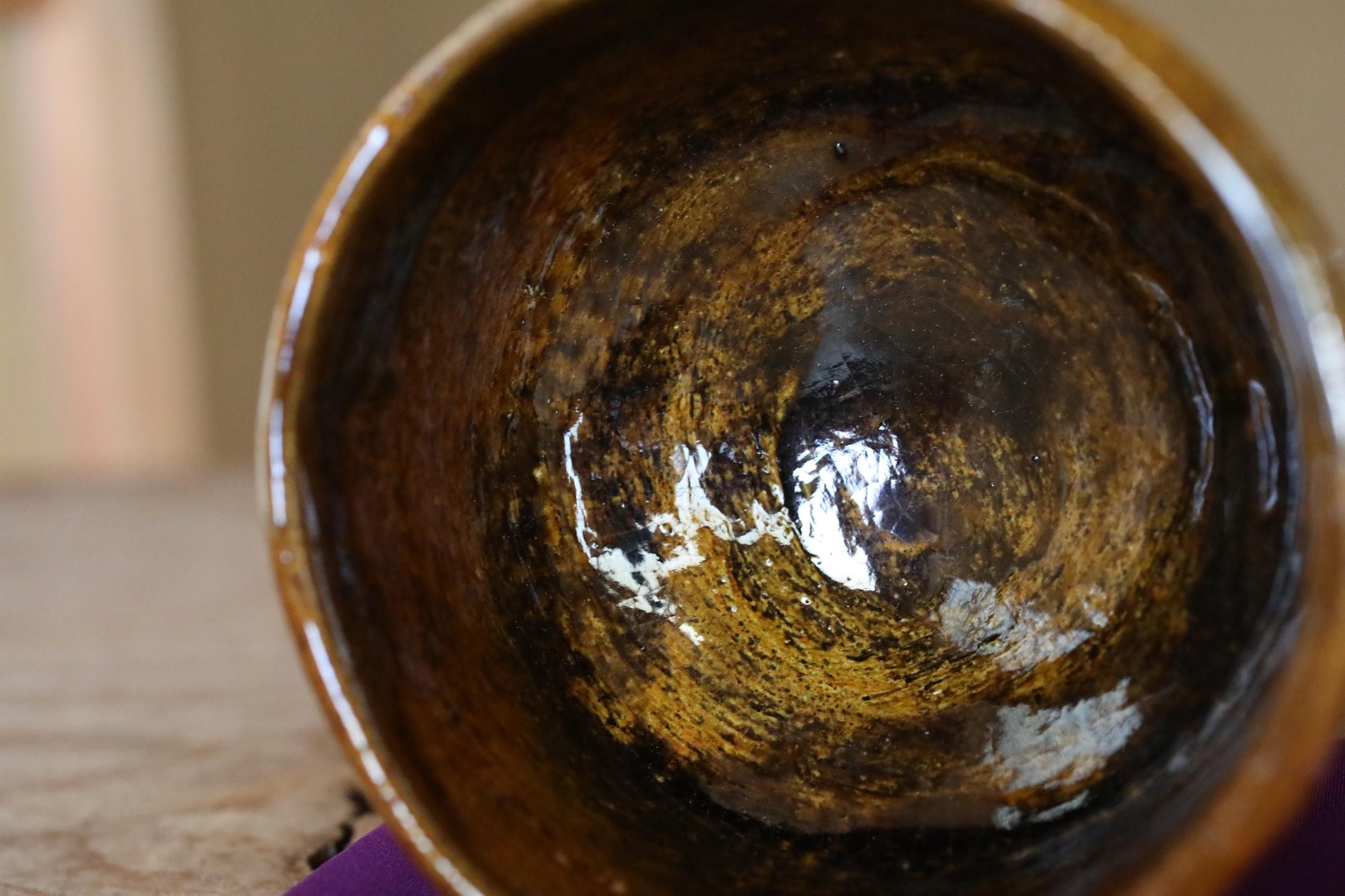a close-up view of a brown, textured bowl with a white speckled design inside.