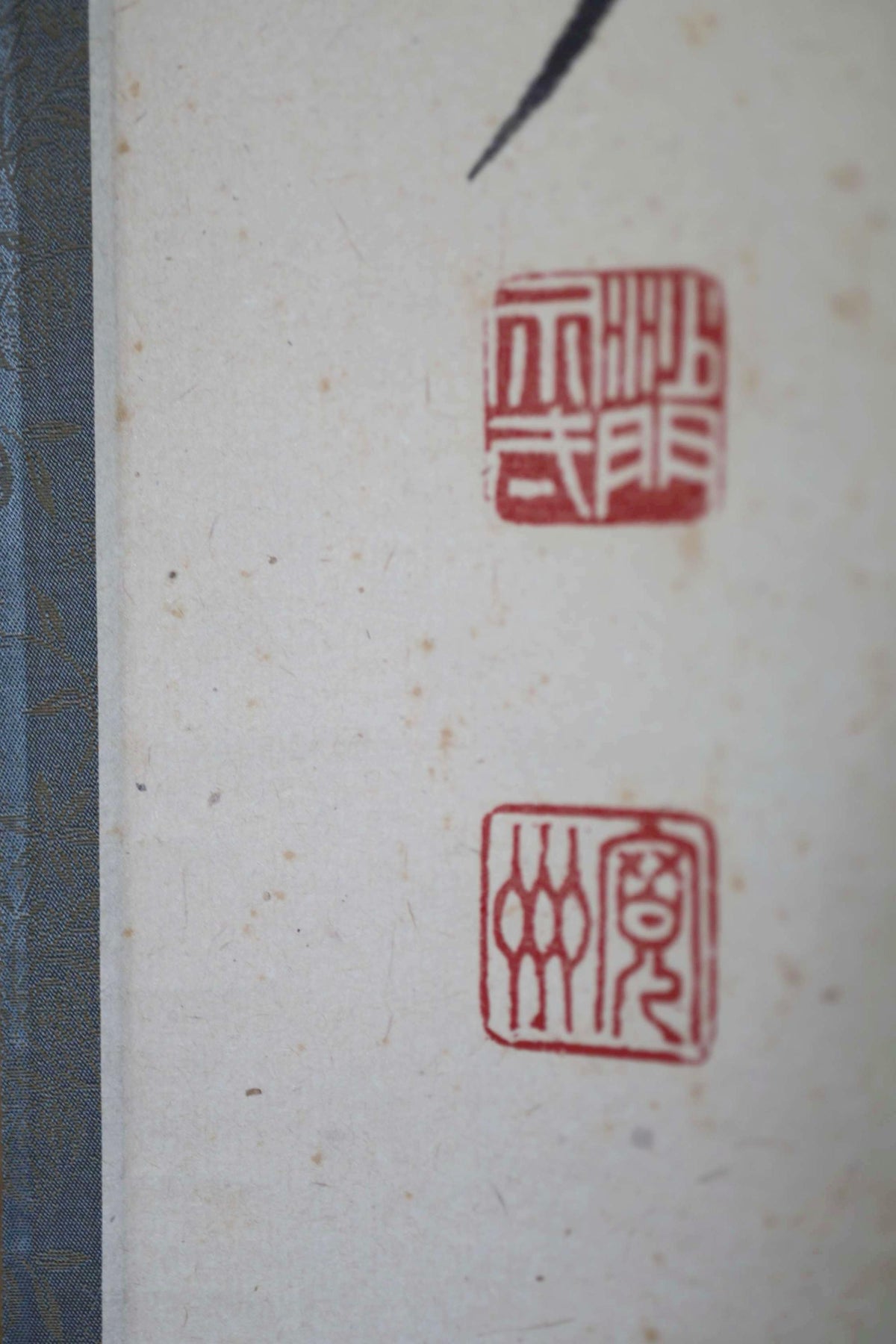 two red Chinese characters on a white background, which appear to be part of a larger composition.