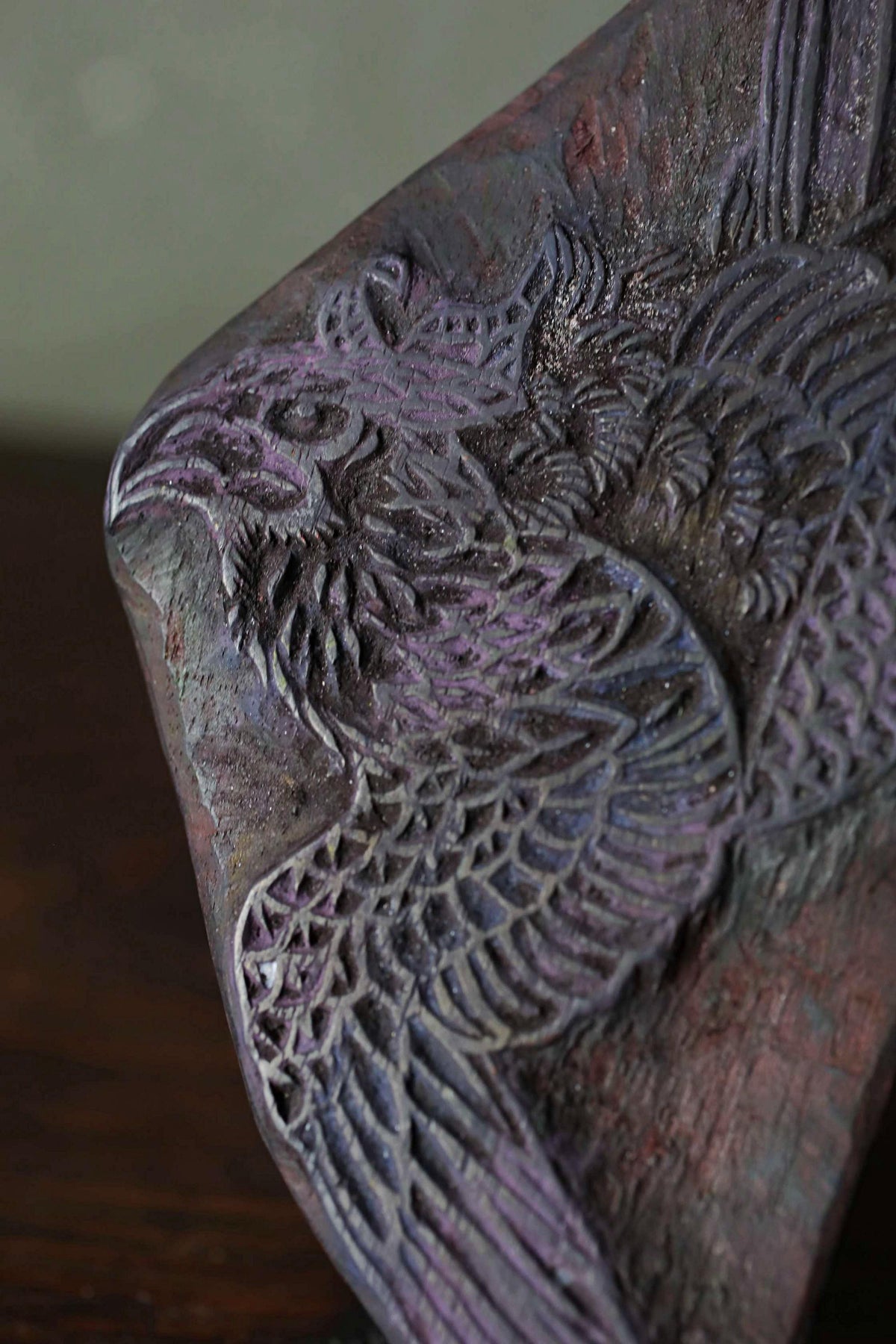 a close-up view of a detailed, intricately carved wooden sculpture depicting a bird or bird-like creature.