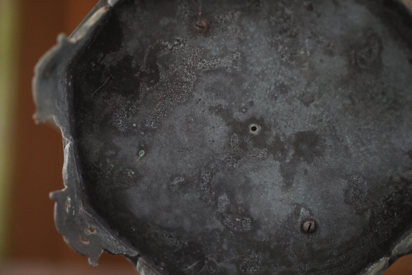 a close-up view of a metal surface with a textured, weathered appearance.
