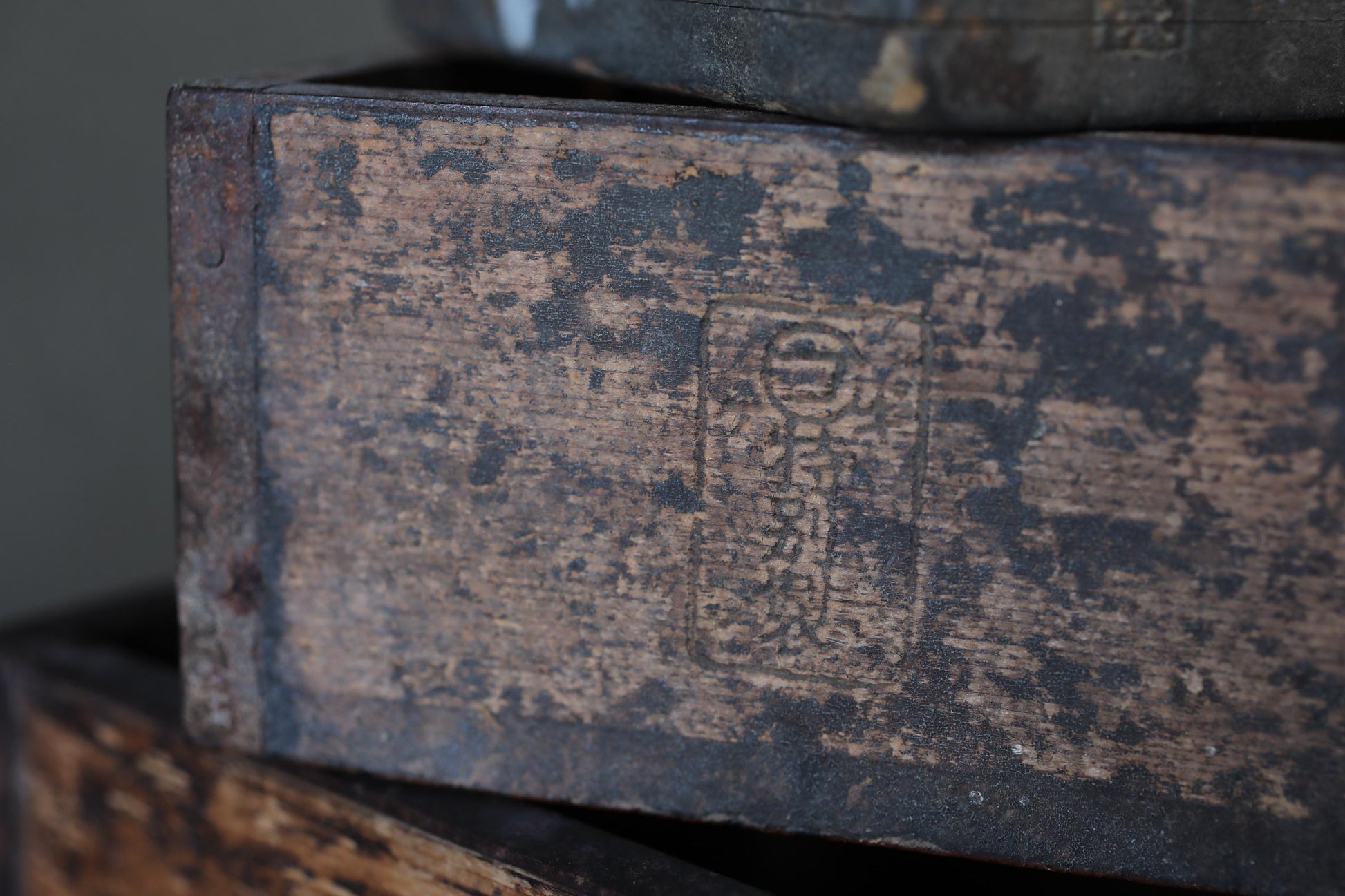 a close-up view of a weathered, wooden surface with a faded, distressed appearance.