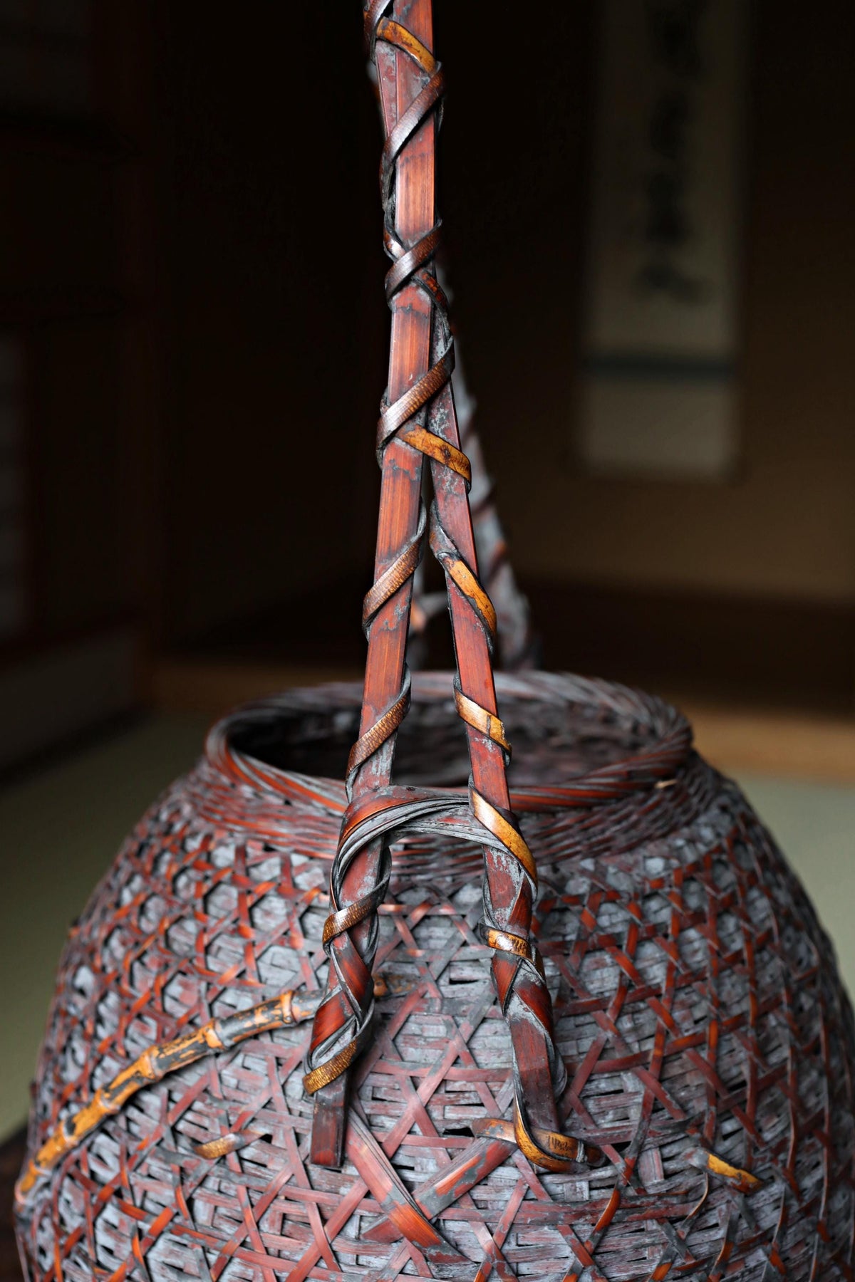A close-up image of a woven basket with a reddish-brown color and intricate patterns.