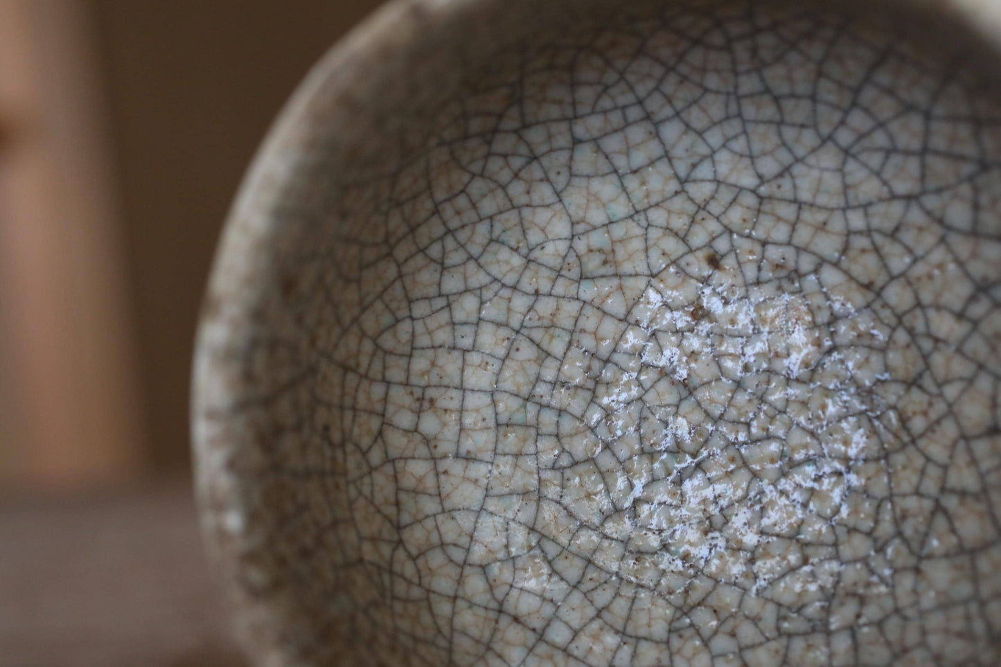 A close-up view of a ceramic bowl with a textured, cracked surface.