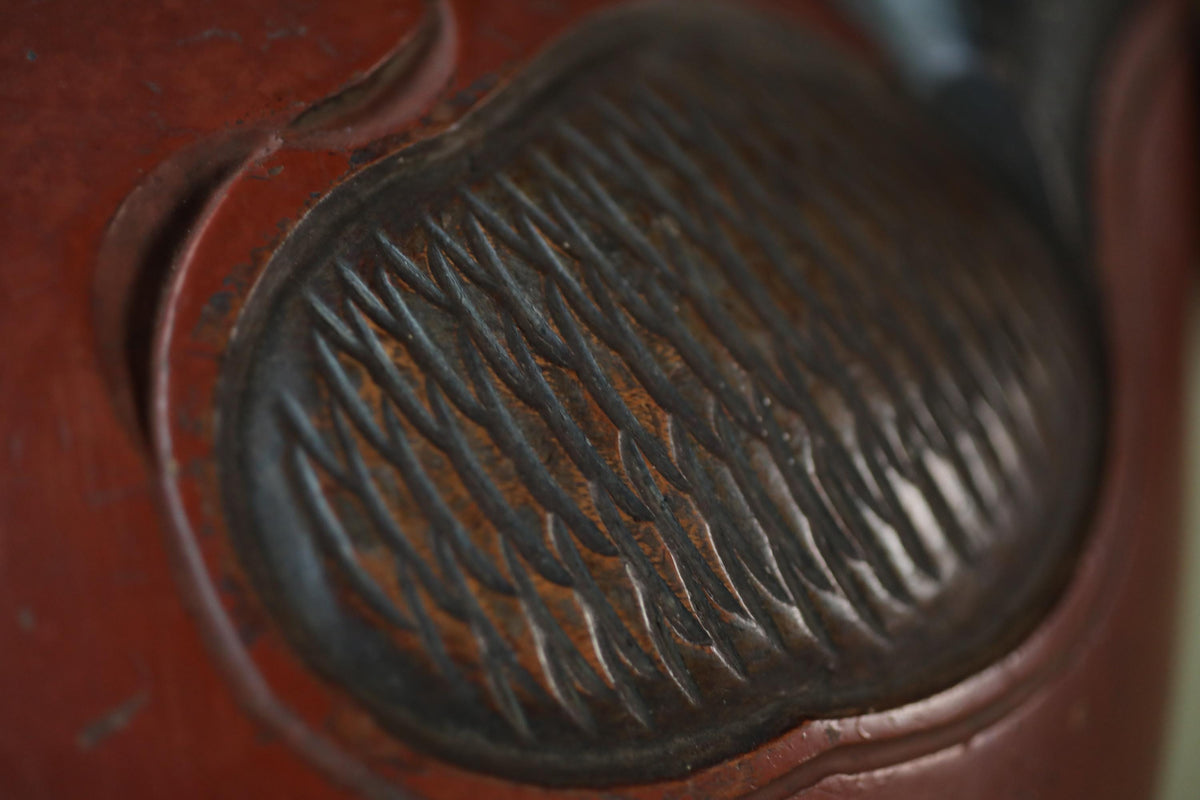 A close-up view of a textured surface with a dark, metallic pattern.