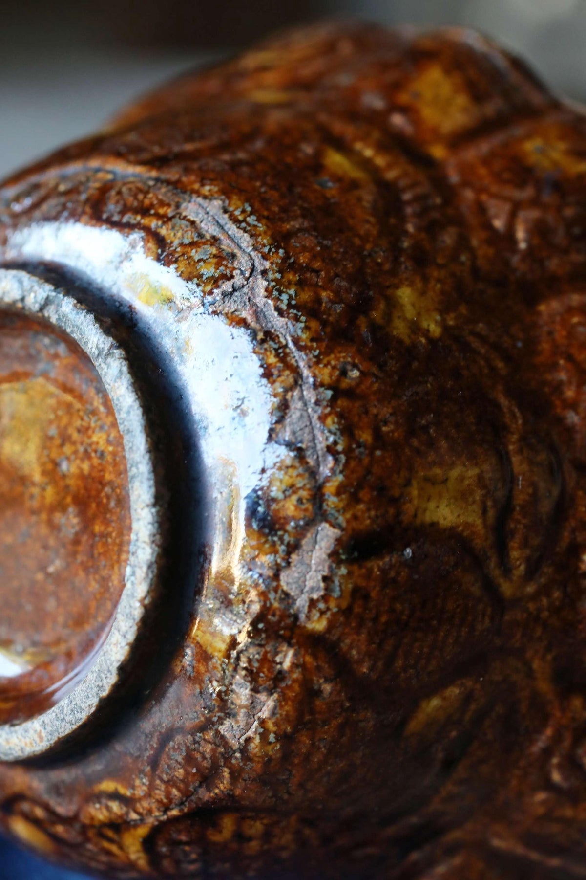 A close-up image of a rusted metal object with a textured, weathered appearance.