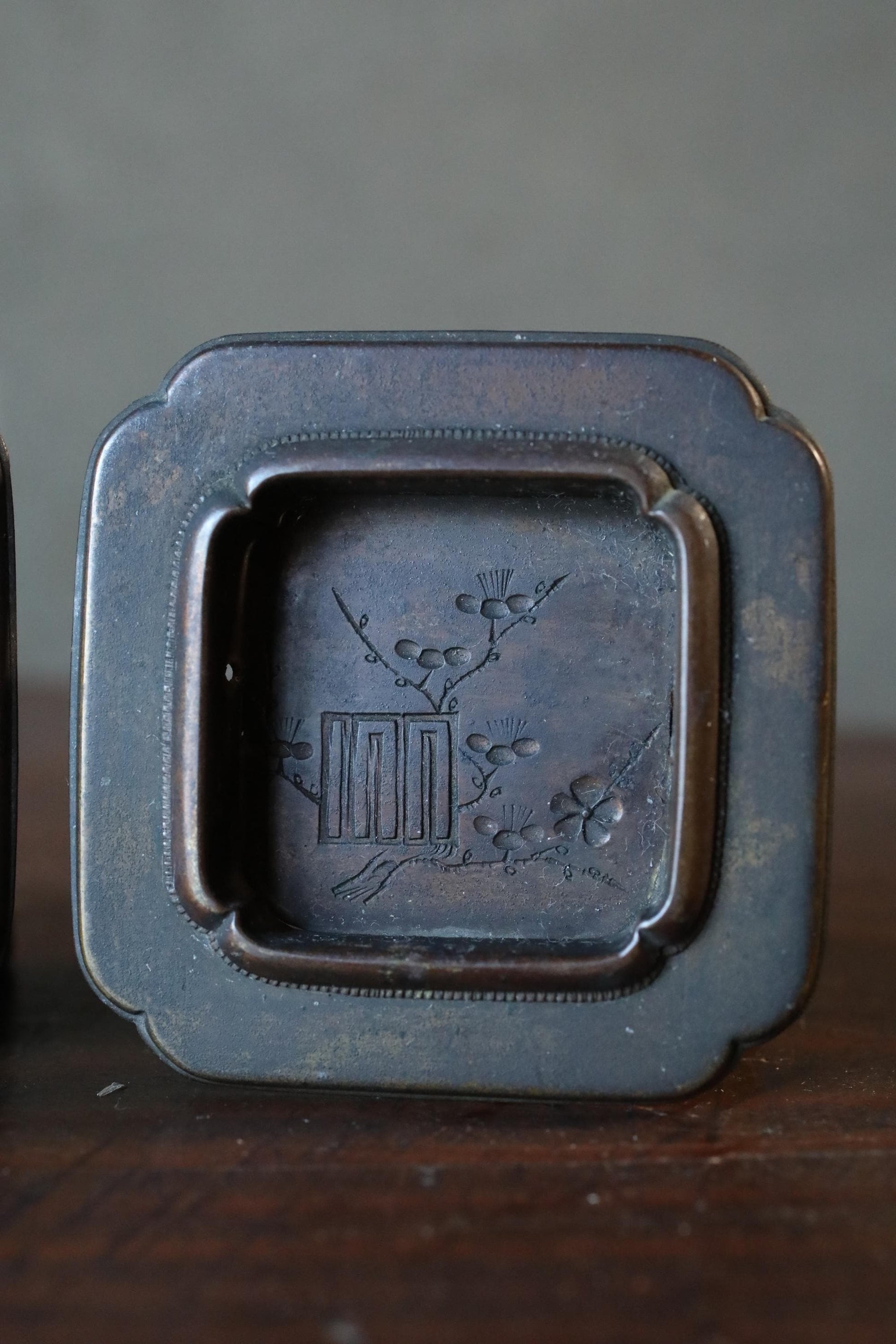 a square metal tray with an embossed design on it.