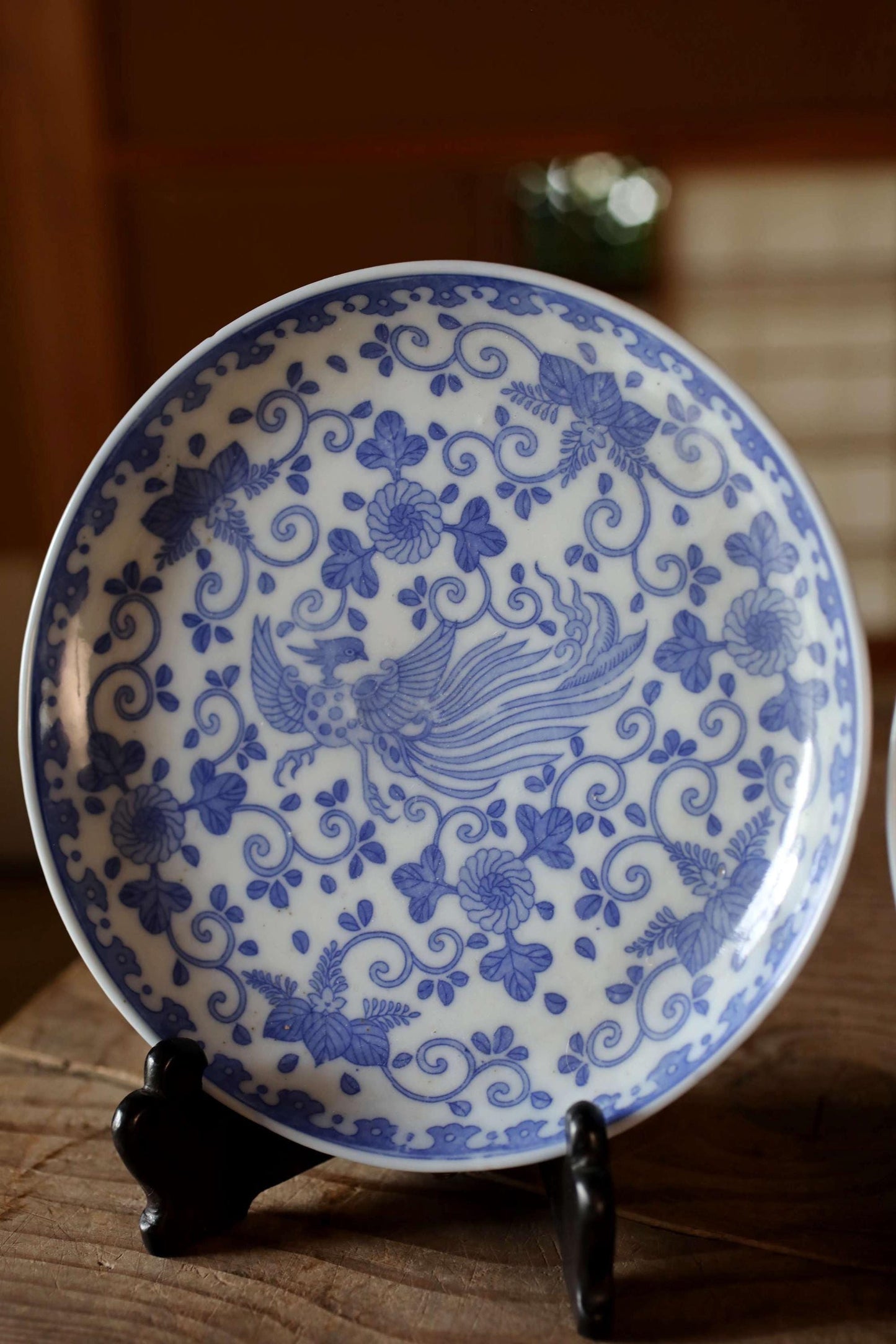 A decorative blue and white plate with a floral pattern, displayed on a wooden surface.