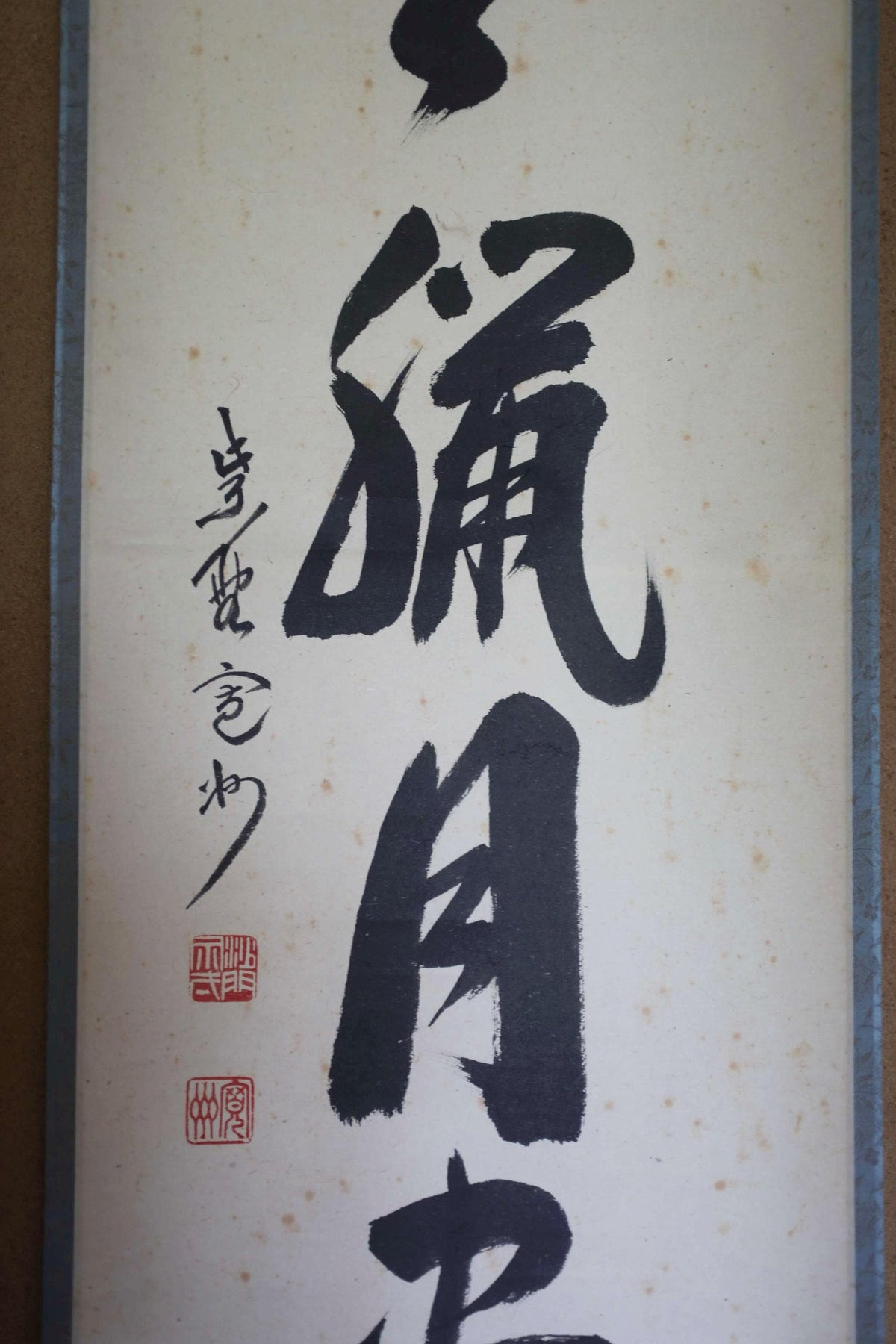 a close-up view of a black and white Chinese calligraphy piece with a large, bold character in the center.
