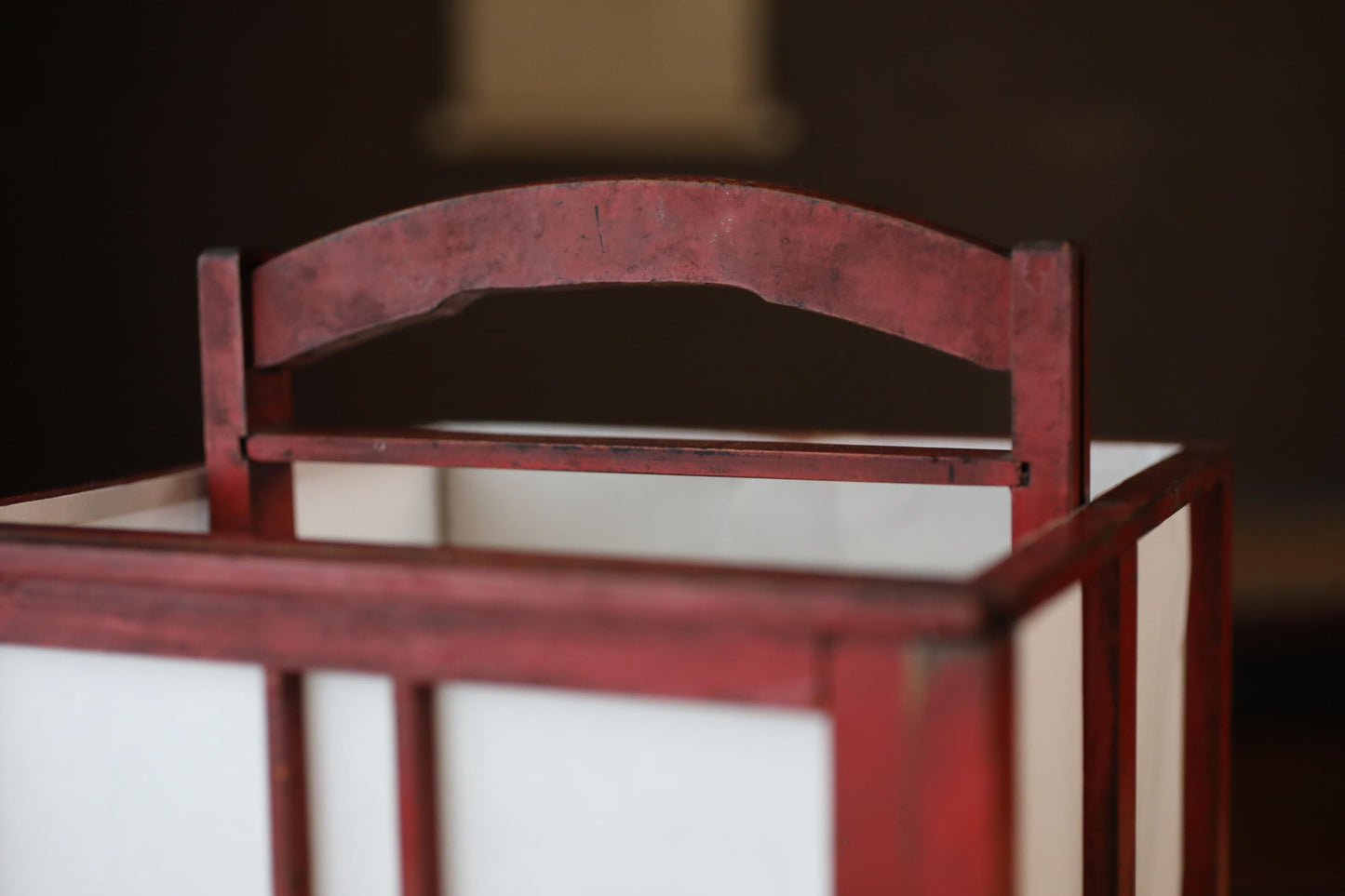 A close-up view of a red wooden chair with a curved backrest.