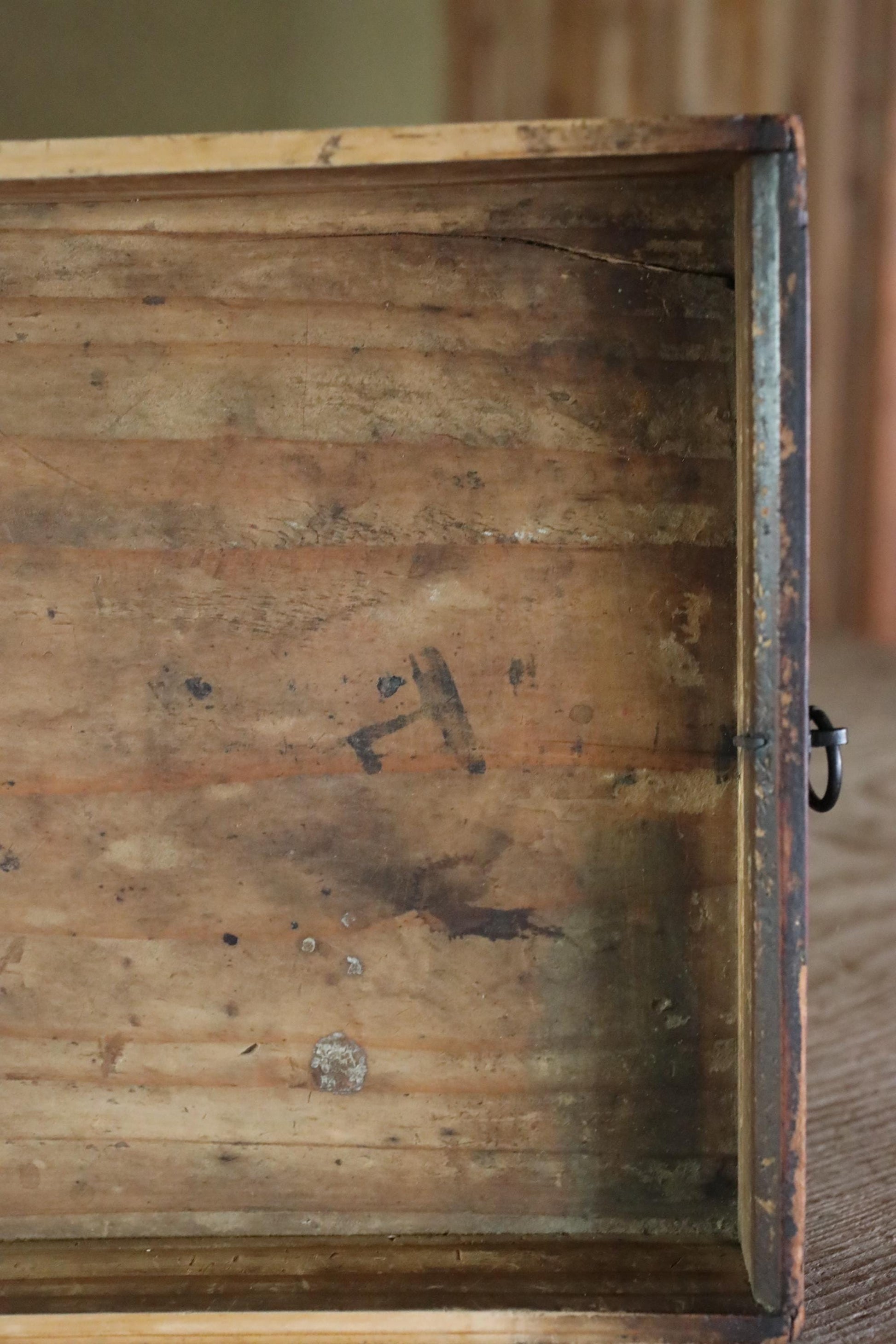 an old, weathered wooden box with visible signs of wear and tear, including peeling paint and visible damage.