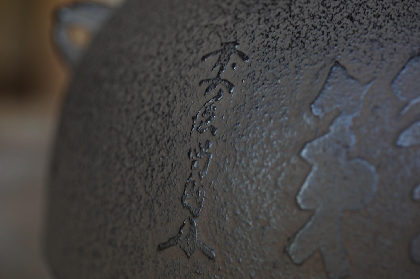 a close-up view of a textured surface with a vertical line of characters etched into it.