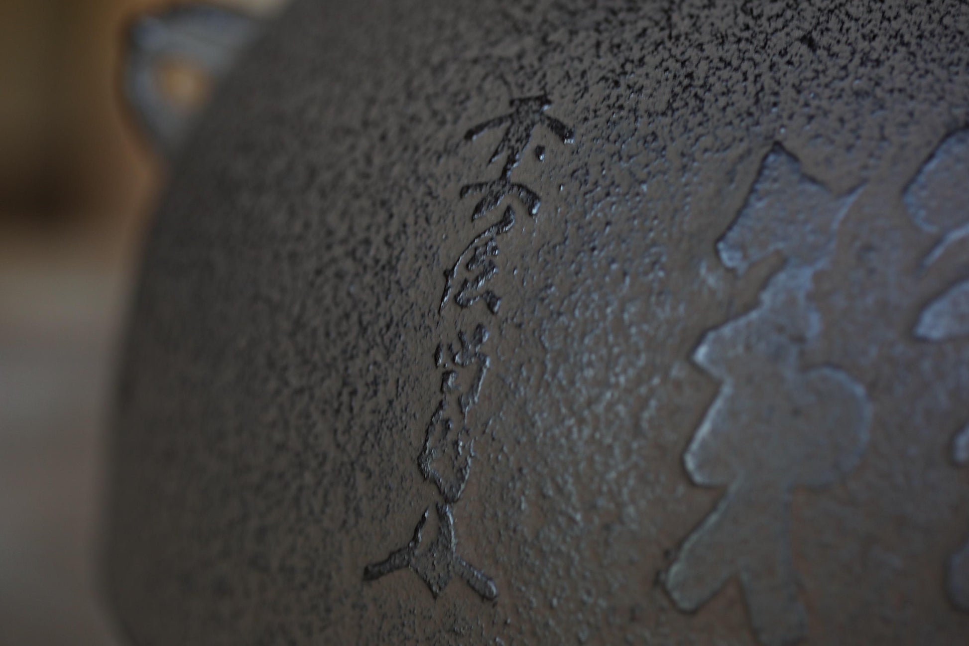 a close-up view of a textured surface with a vertical line of characters etched into it.