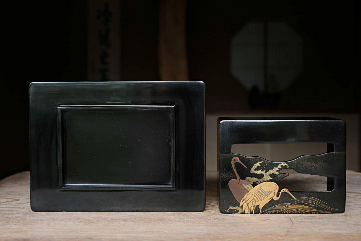 two black rectangular objects placed on a wooden surface.