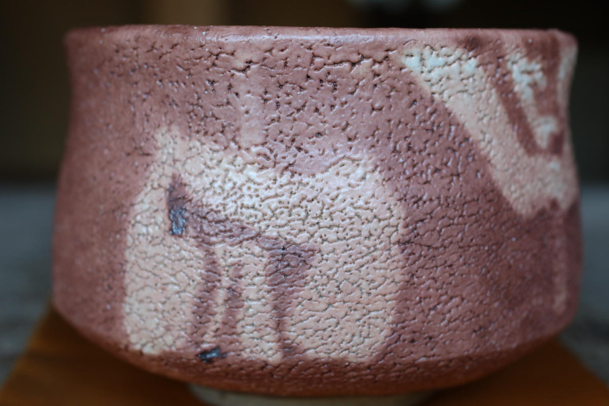 A close-up image of a ceramic bowl with a textured surface, featuring a pattern of brown and white colors.