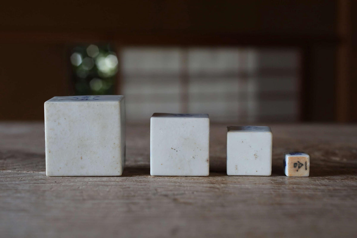 Three white ceramic blocks of varying sizes are arranged on a wooden surface.