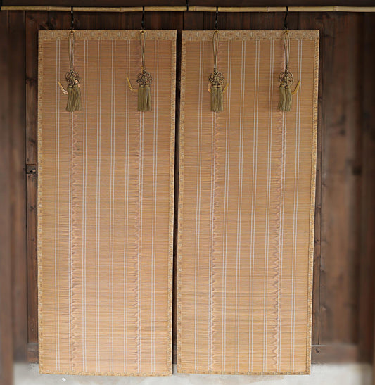 a pair of wooden blinds hanging on a wall, with tassels hanging from them.