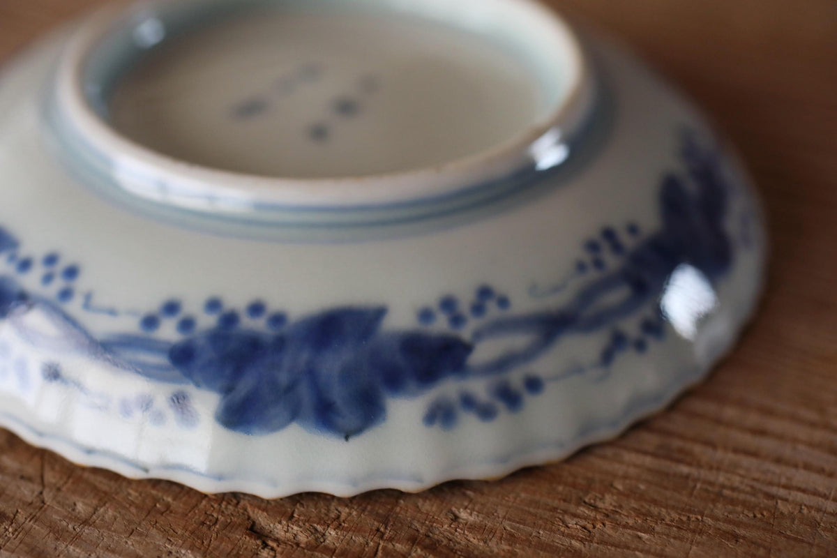 A close-up image of a blue and white ceramic plate with a floral design, resting on a wooden surface.