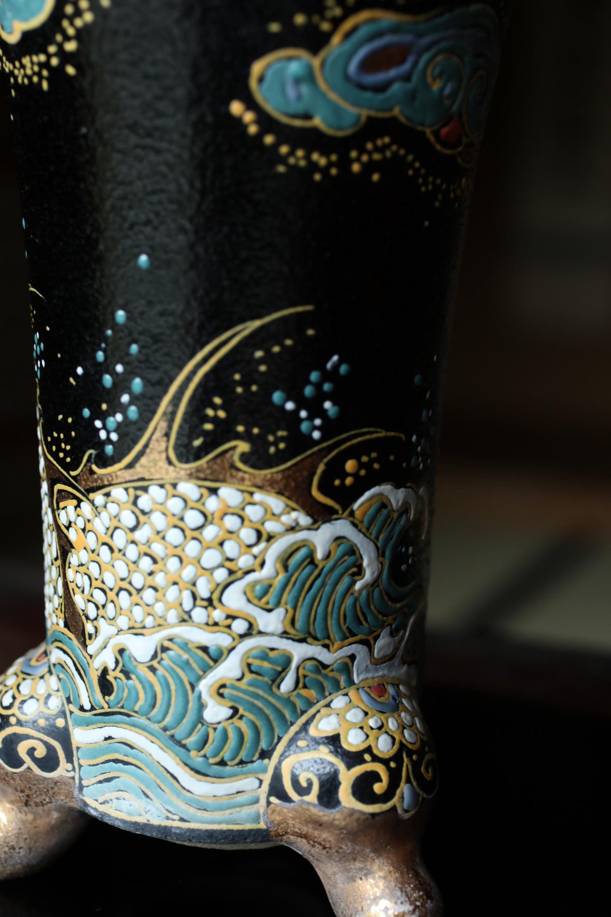 A close-up view of a decorative vase with intricate patterns and designs in gold, blue, and white colors.