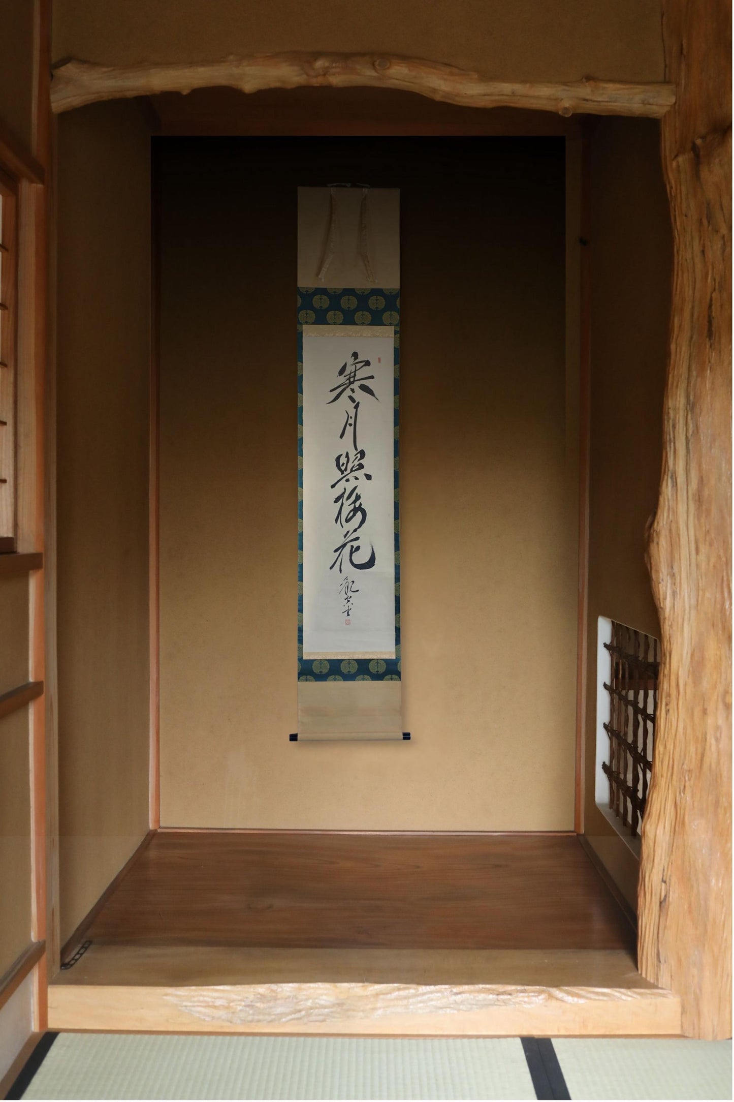 a traditional Japanese room with a wooden floor and a wooden wall. There is a vertical banner hanging on the wall with Japanese characters.