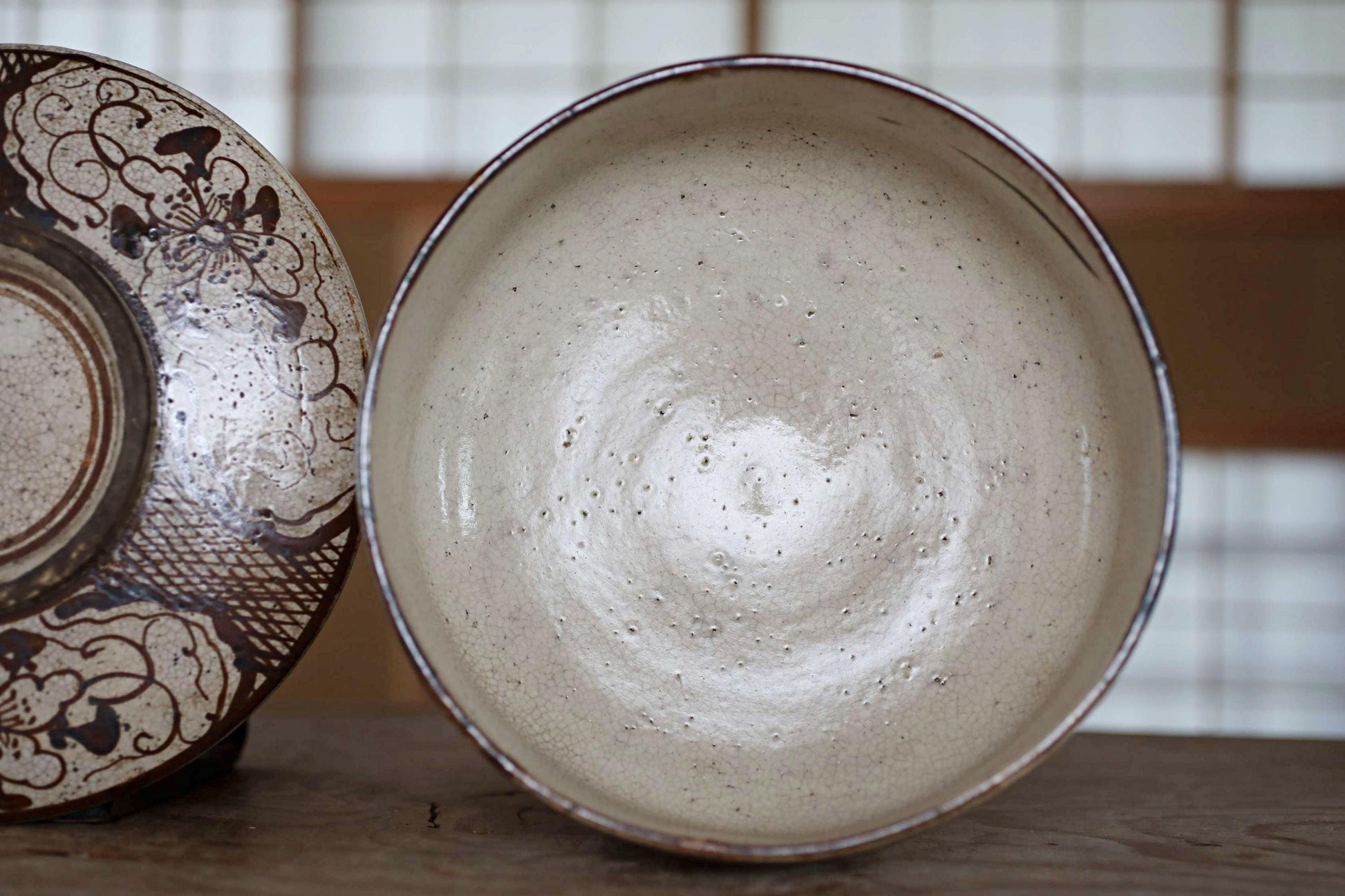 a close-up view of a white ceramic bowl with a brown rim, placed on a wooden surface.