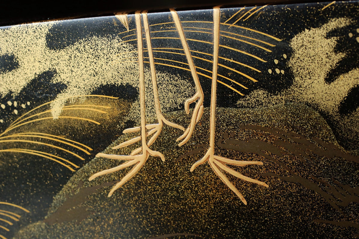 a close-up view of a pair of bird legs, with intricate gold and black patterns and designs surrounding them.
