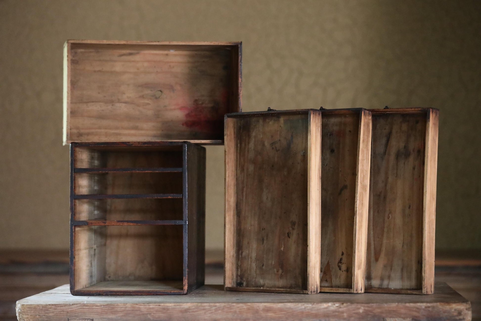 a collection of wooden boxes and trays, some of which are open, sitting on a wooden surface.