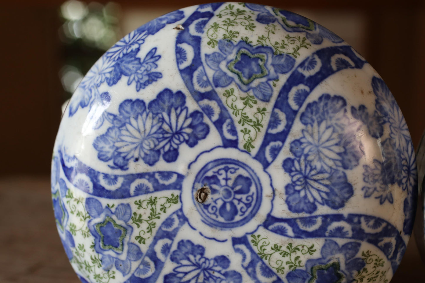 A close-up image of a decorative blue and white ceramic bowl or vase with intricate floral patterns and designs.