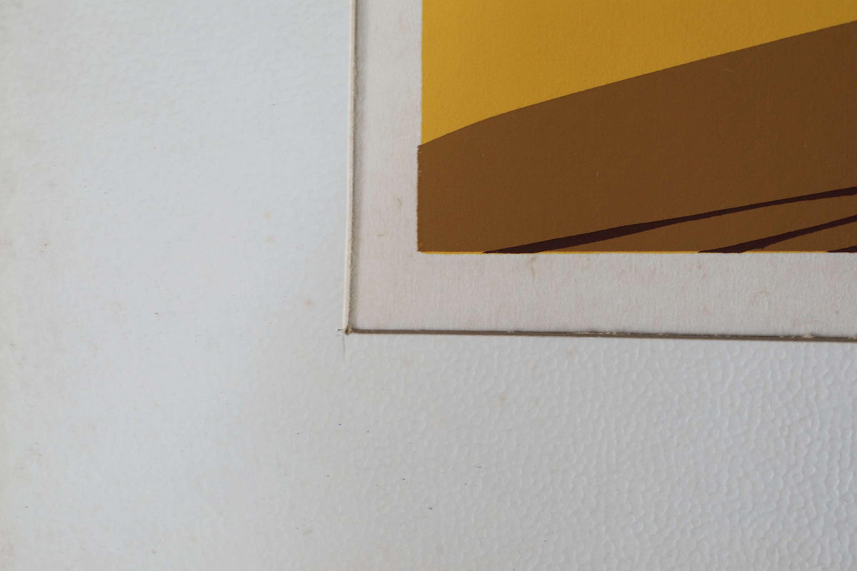 The image is a close-up of a white surface with a yellow and brown abstract painting or artwork.