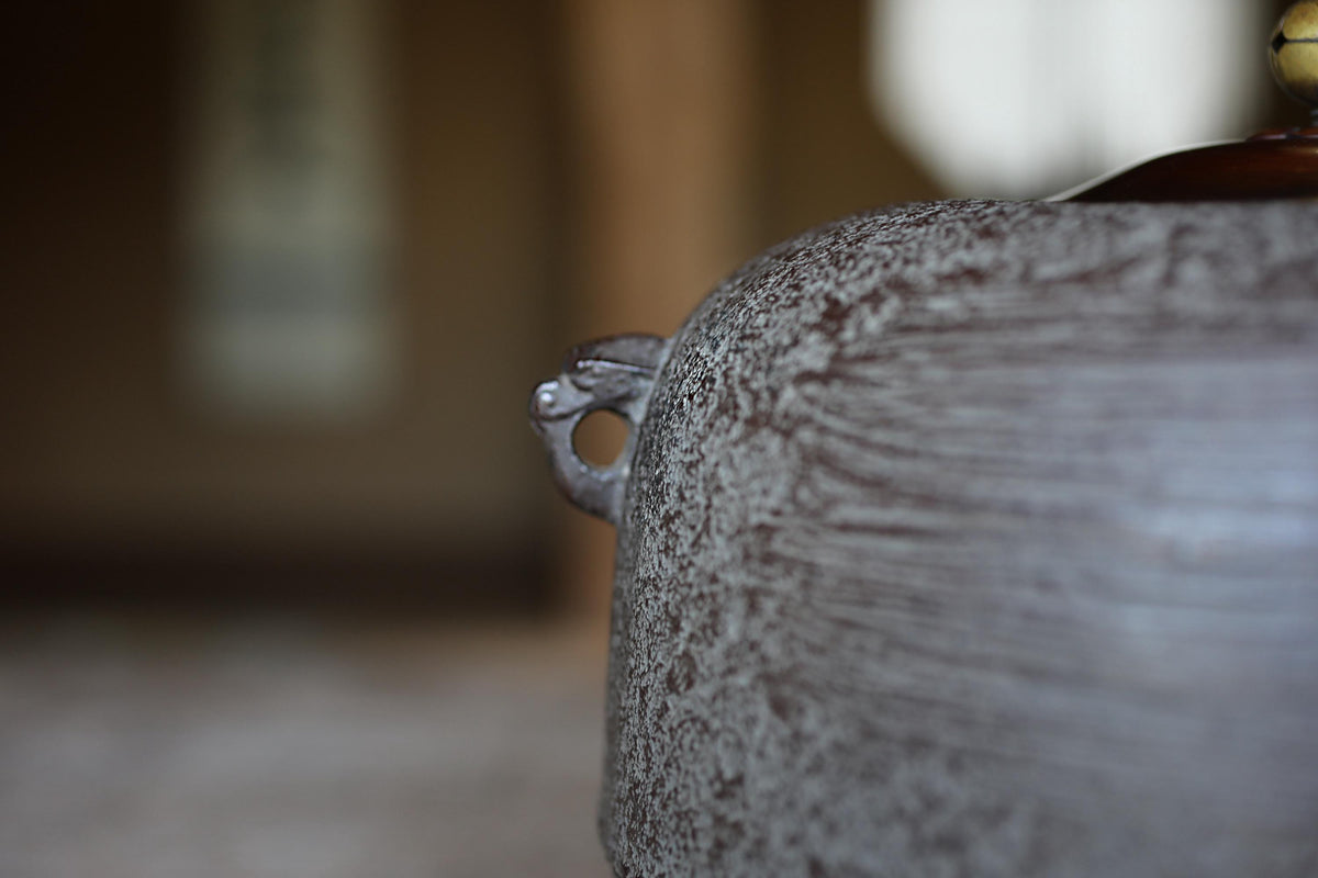 A close-up view of a metal object with a textured surface, possibly a piece of furniture or a decorative item.