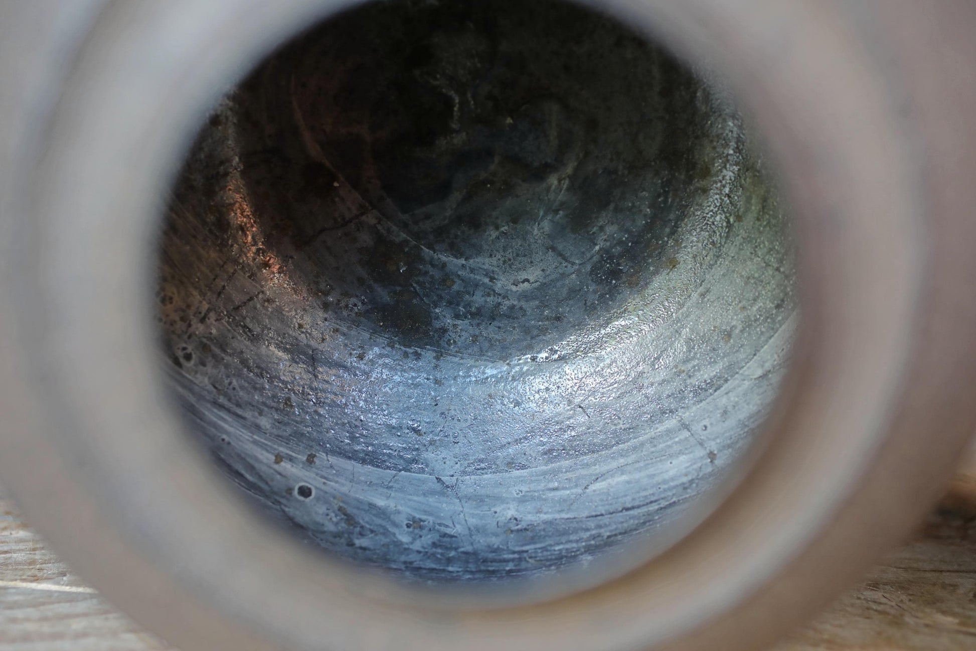 a close-up view of a metal pipe or tube, with a textured and weathered appearance.