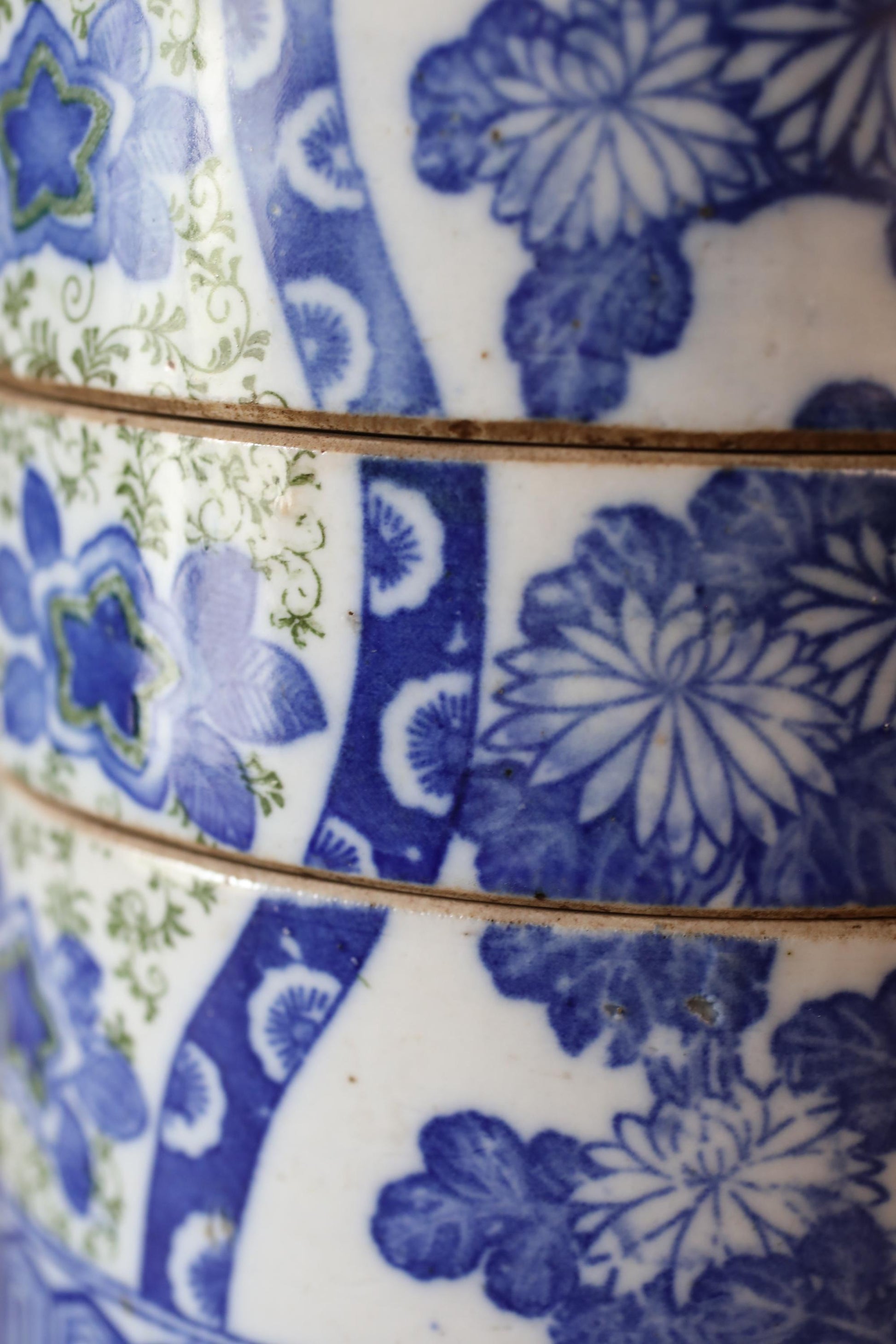 a close-up view of a decorative ceramic piece with a blue and white floral pattern. The piece appears to be a vase or bowl, with intricate designs and patterns covering its surface.