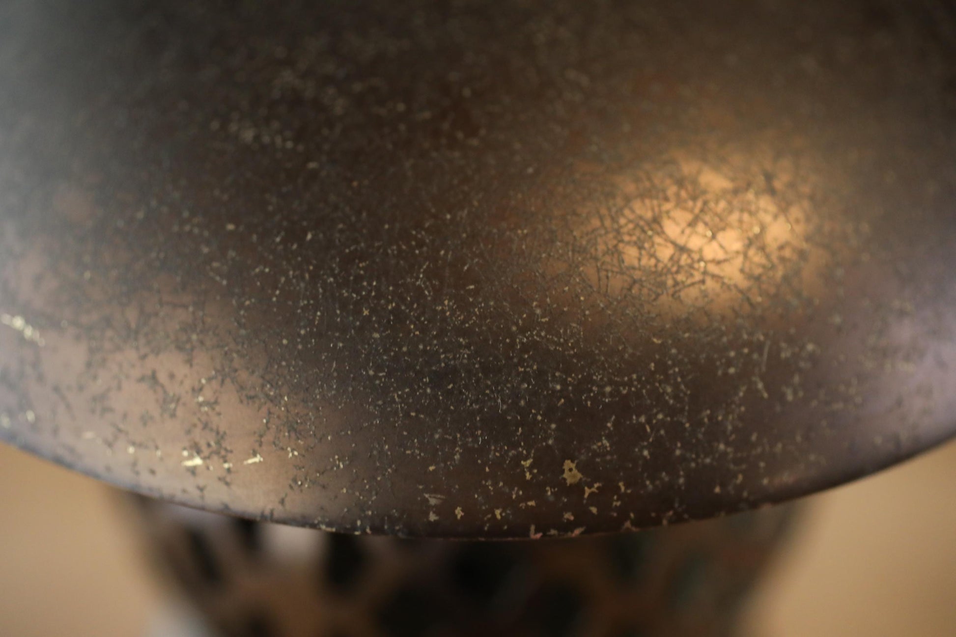 a close-up view of a textured surface, possibly a lamp shade or a piece of furniture, with a warm, golden glow.