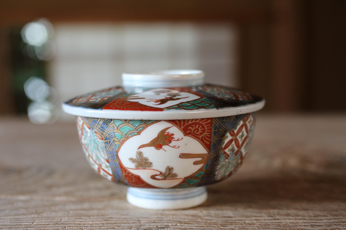 A colorful ceramic bowl with intricate designs, placed on a wooden surface.