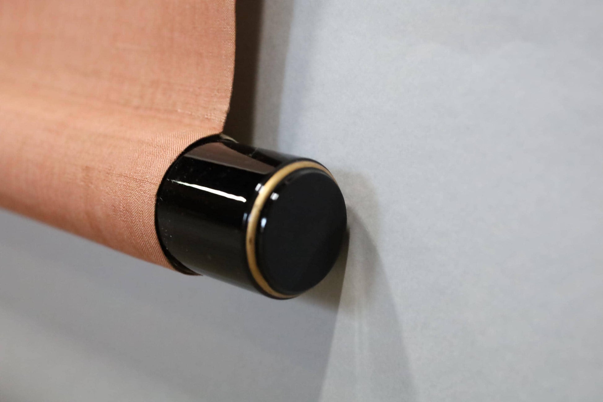 A close-up view of a black and gold scroll or scroll-like object, with a textured orange or brown surface.